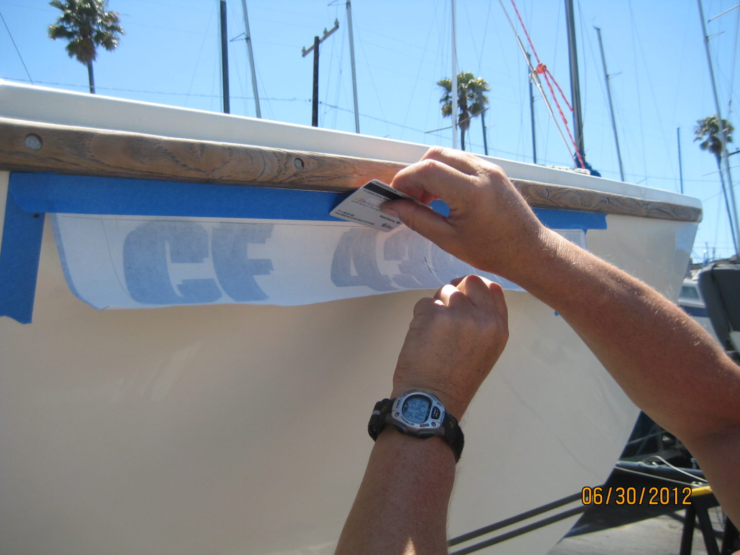 A person is painting the side of a boat.