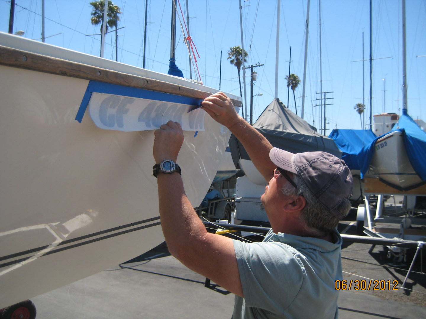 A man is painting the side of a boat.