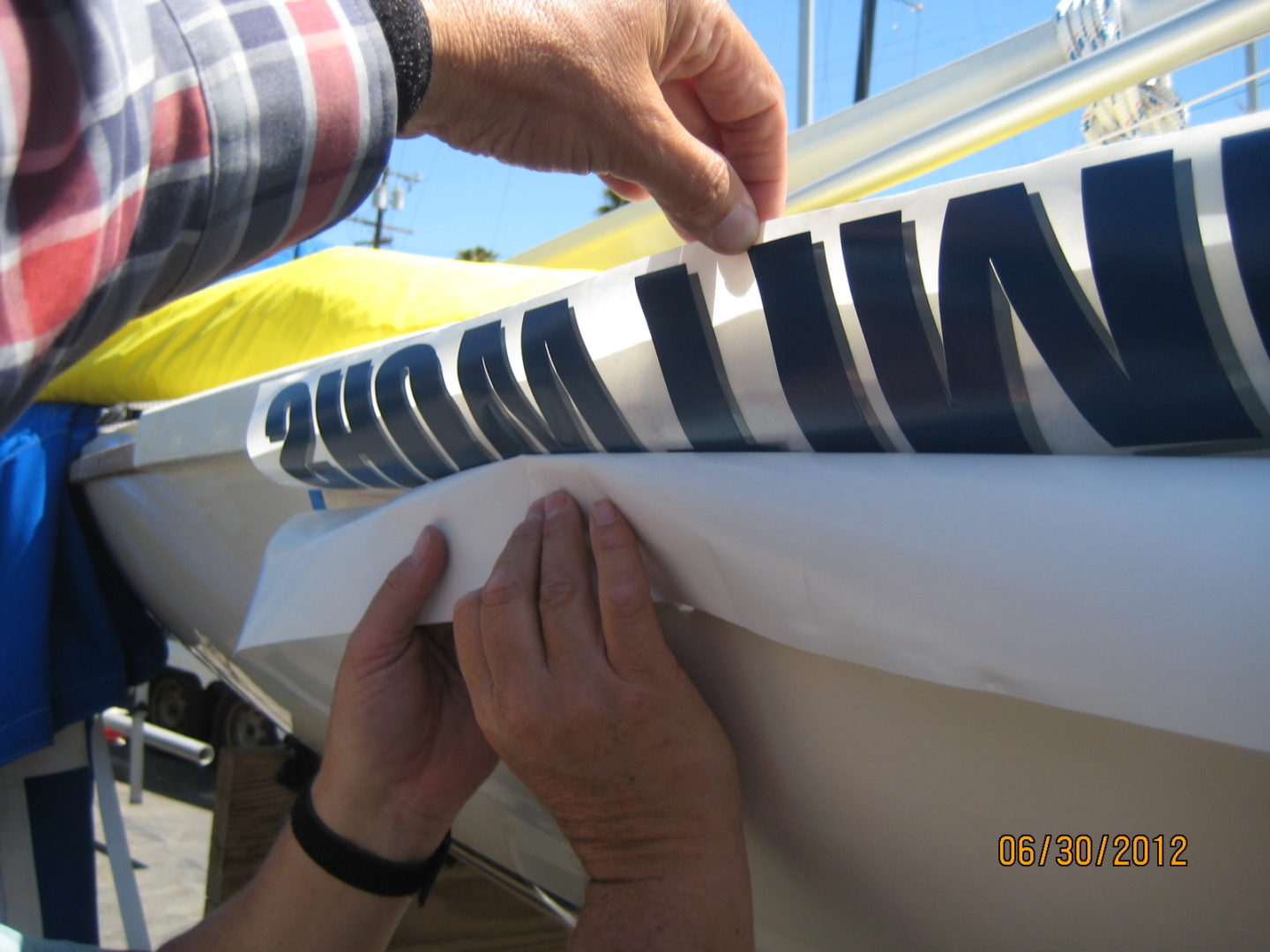 A man is working on the side of a boat.