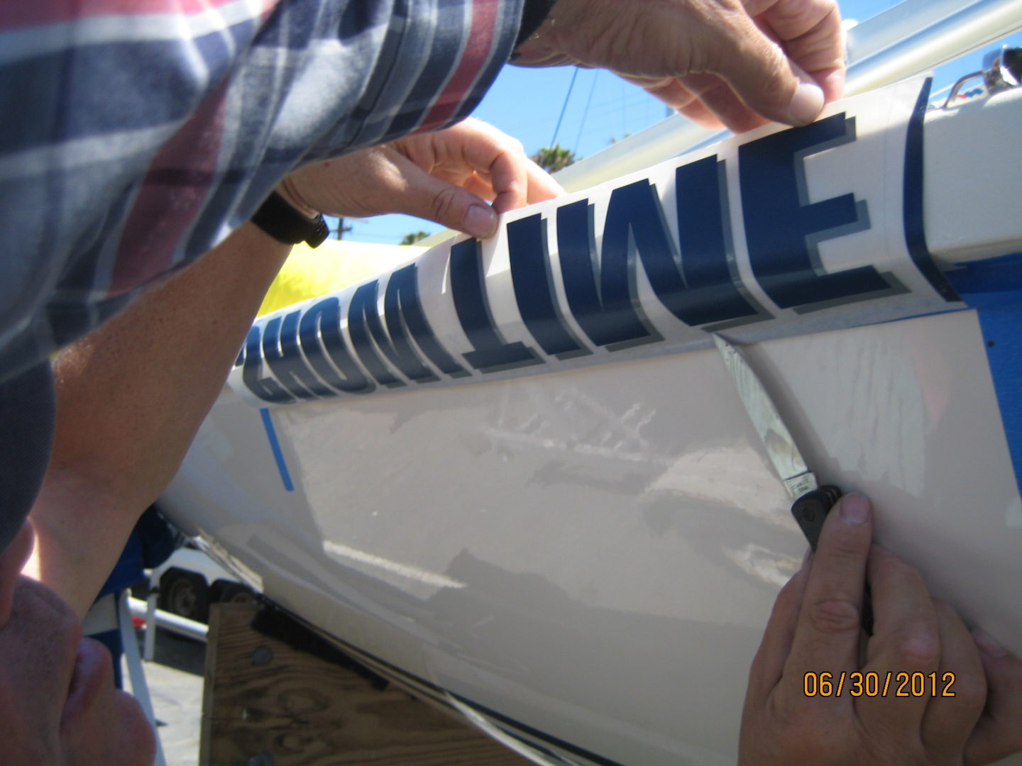 A man is working on the side of a boat.