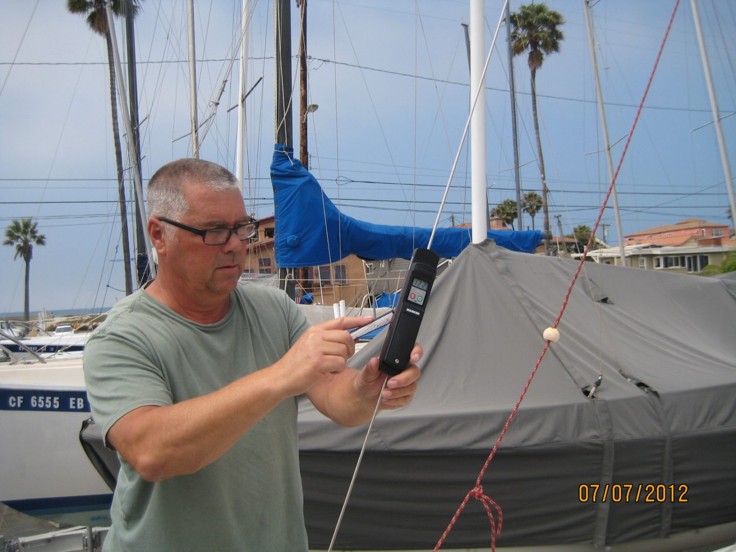 A man holding a remote control in front of a boat.