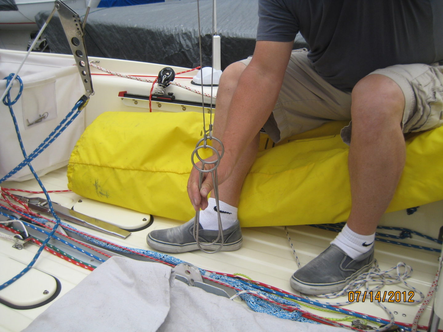 A man tying his shoes on the deck of a boat.