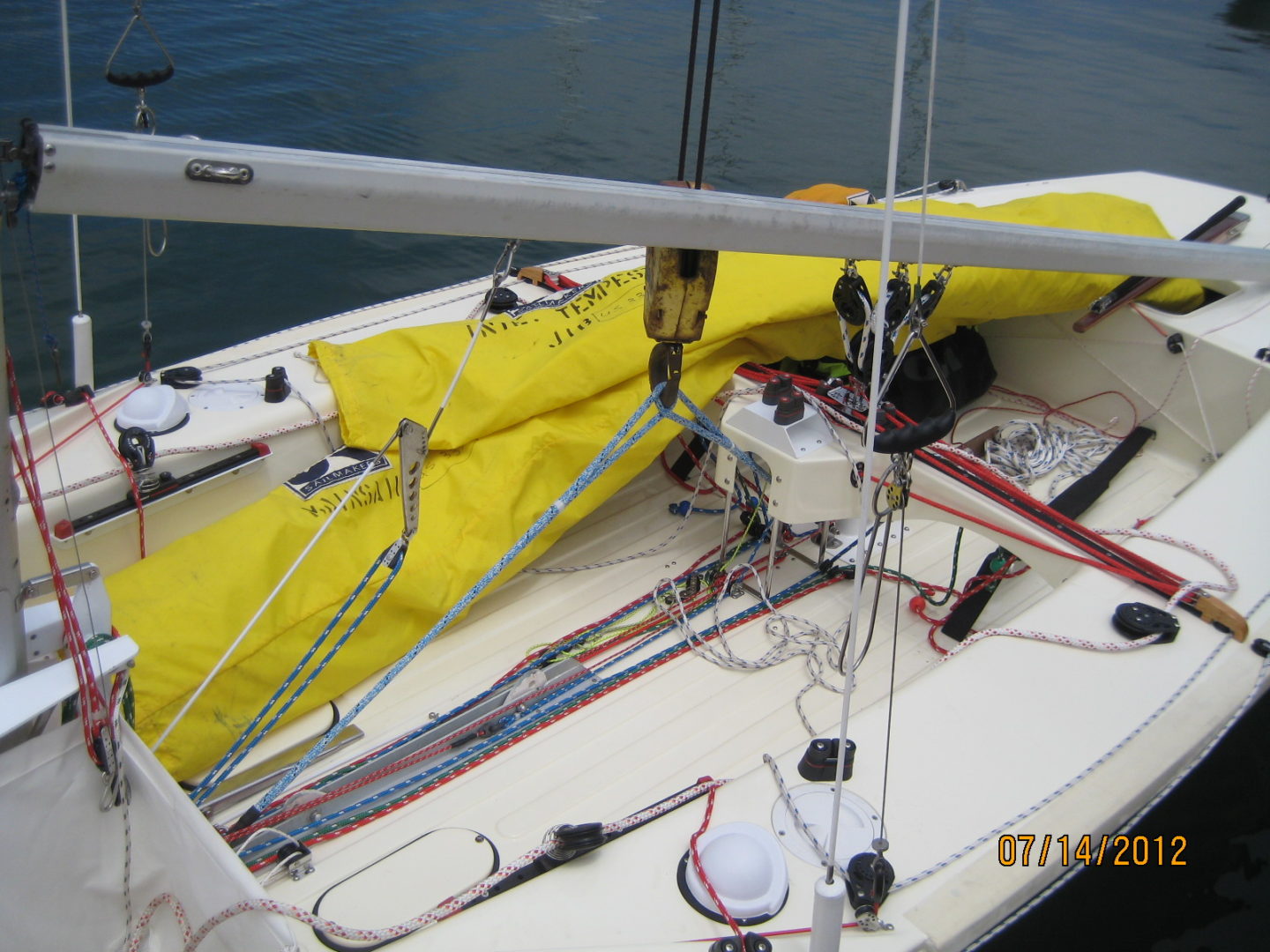 A yellow sail boat with the bow down.