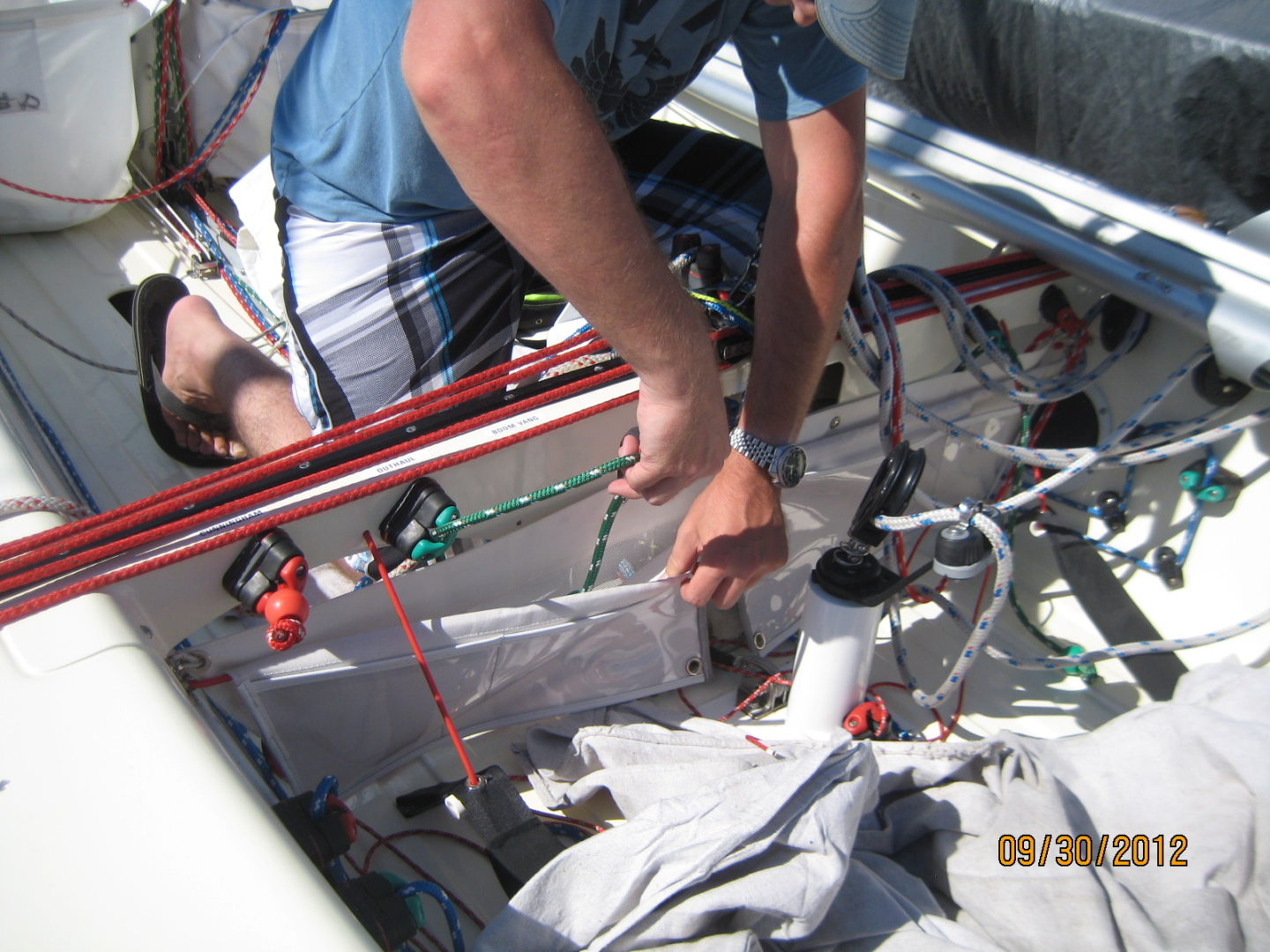 A man is working on the side of a boat.