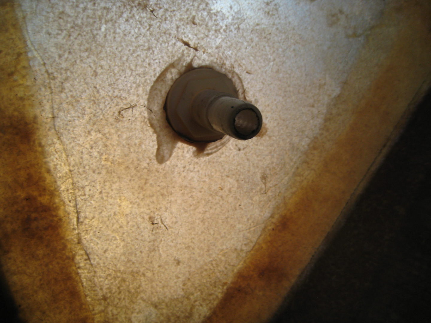 A hole in the wall of an old bathroom.