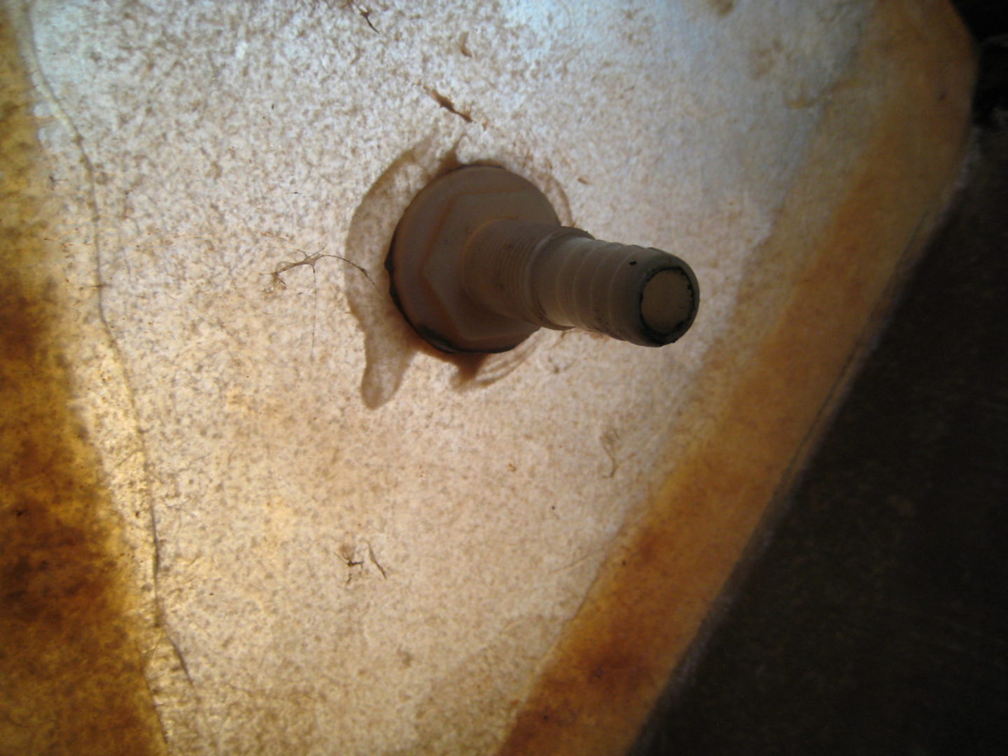 A hole in the wall with a plunger sticking out of it.