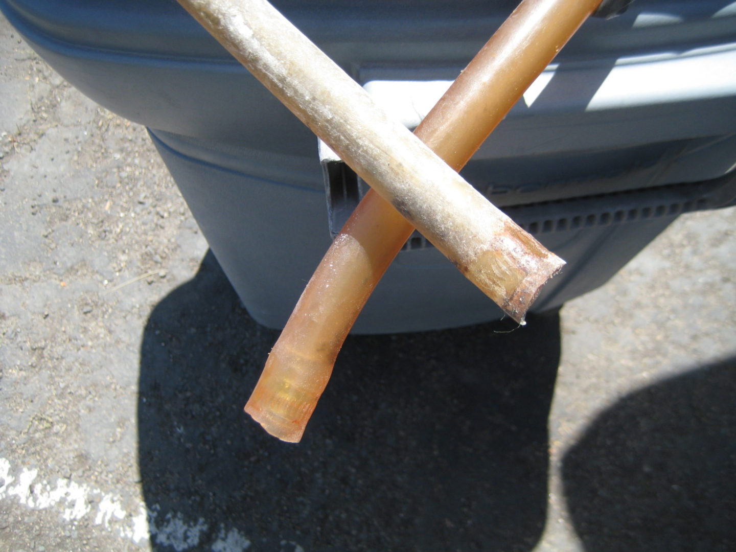 A pair of wooden sticks sitting on top of a trash can.