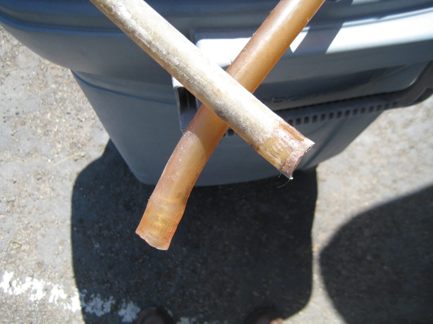 A pair of wooden sticks sitting on top of a trash can.