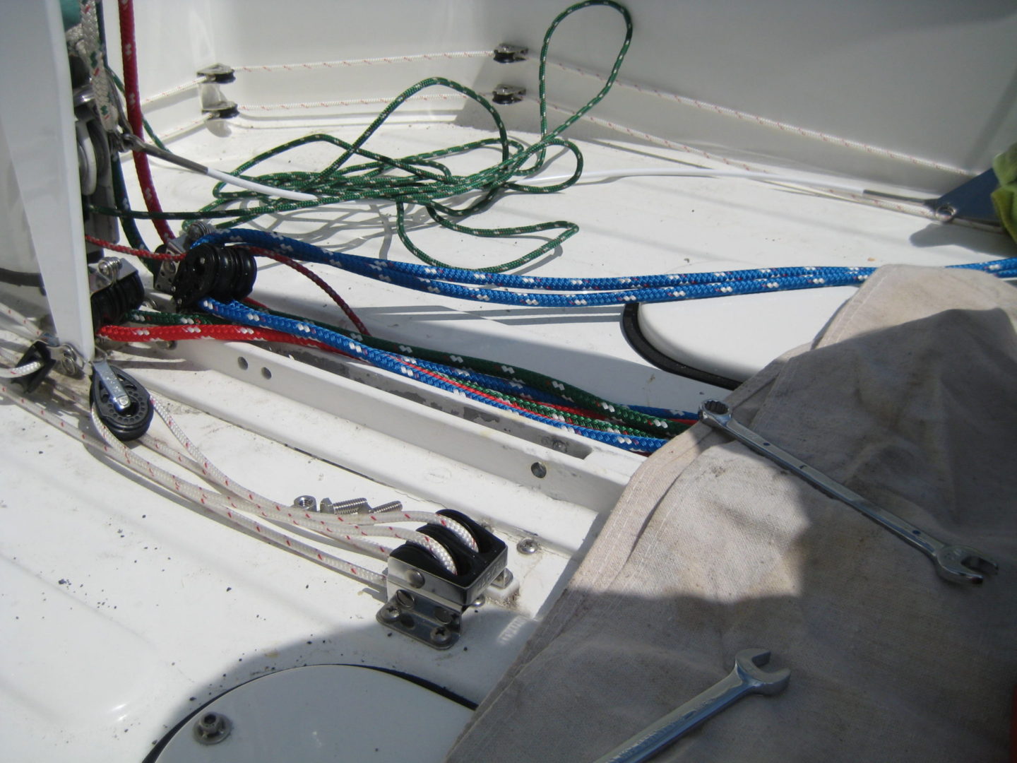 A boat with ropes and cables on the deck.