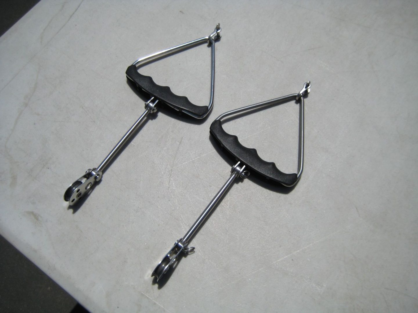 Two triangular shaped metal handles with a handle on each.