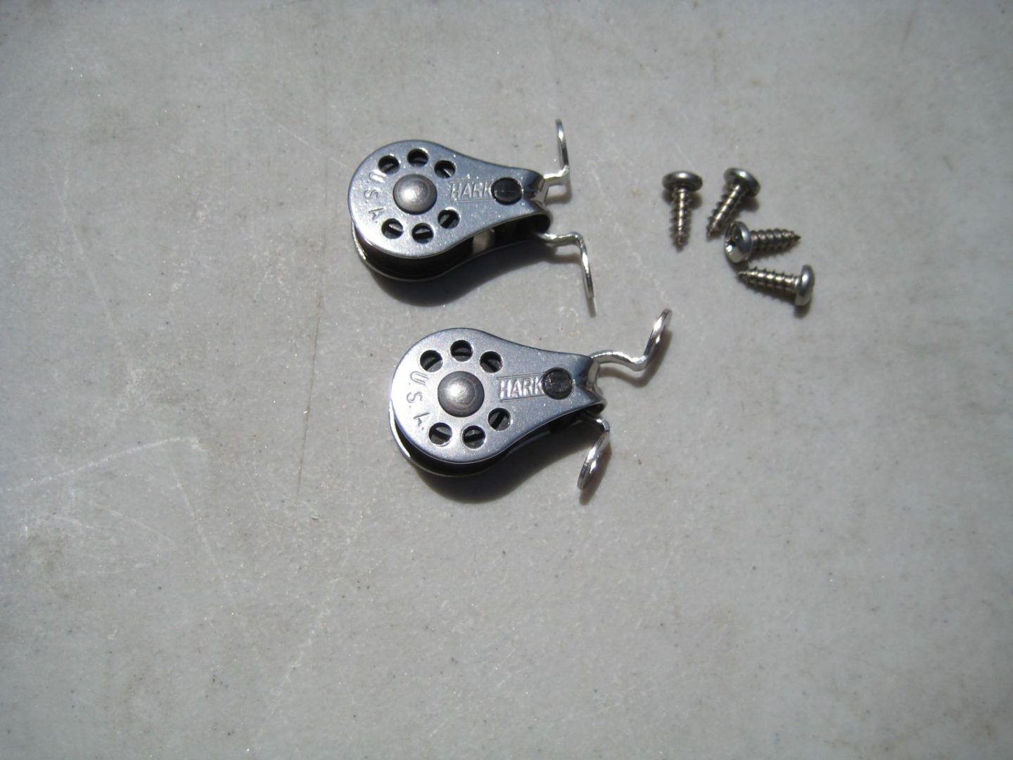 A pair of metal wheels with holes and screws.