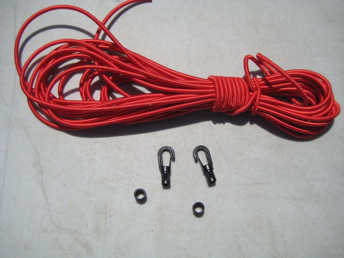 A red string and two black hooks are on the floor.