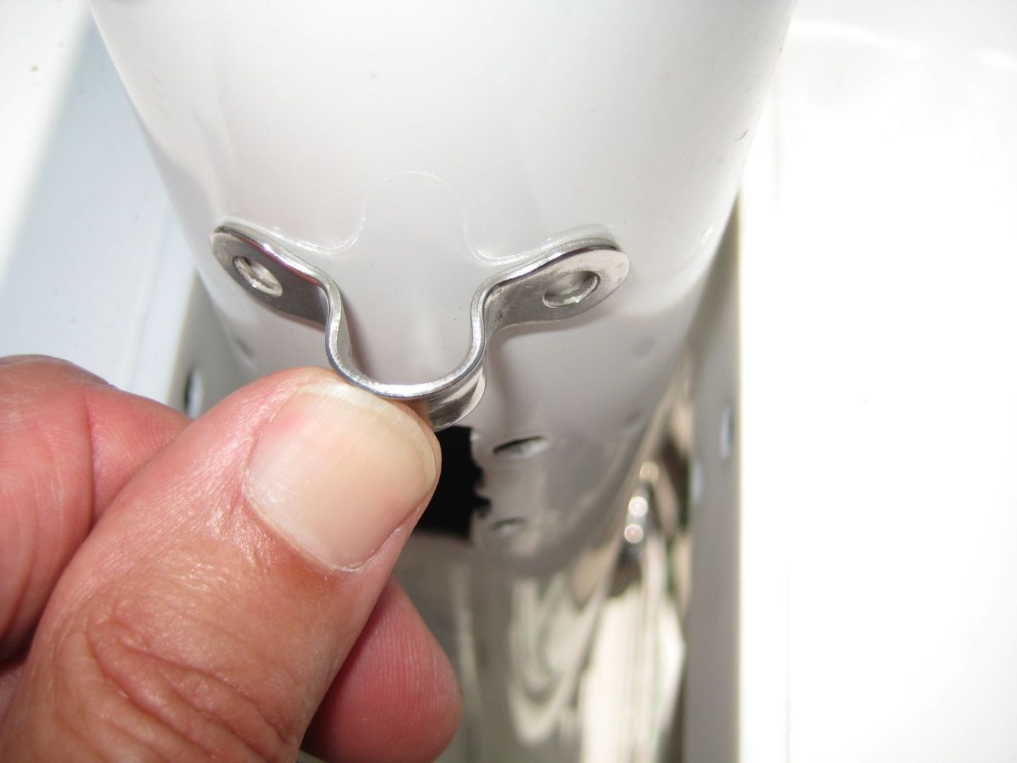 A person is holding onto the handle of a white machine.