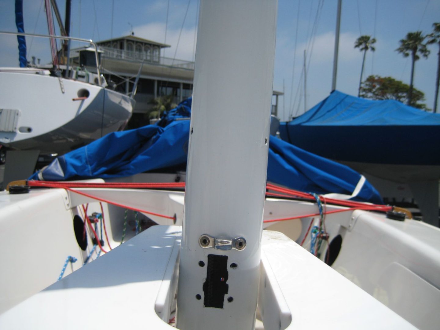 A boat is docked in the water and has blue tarps on it.