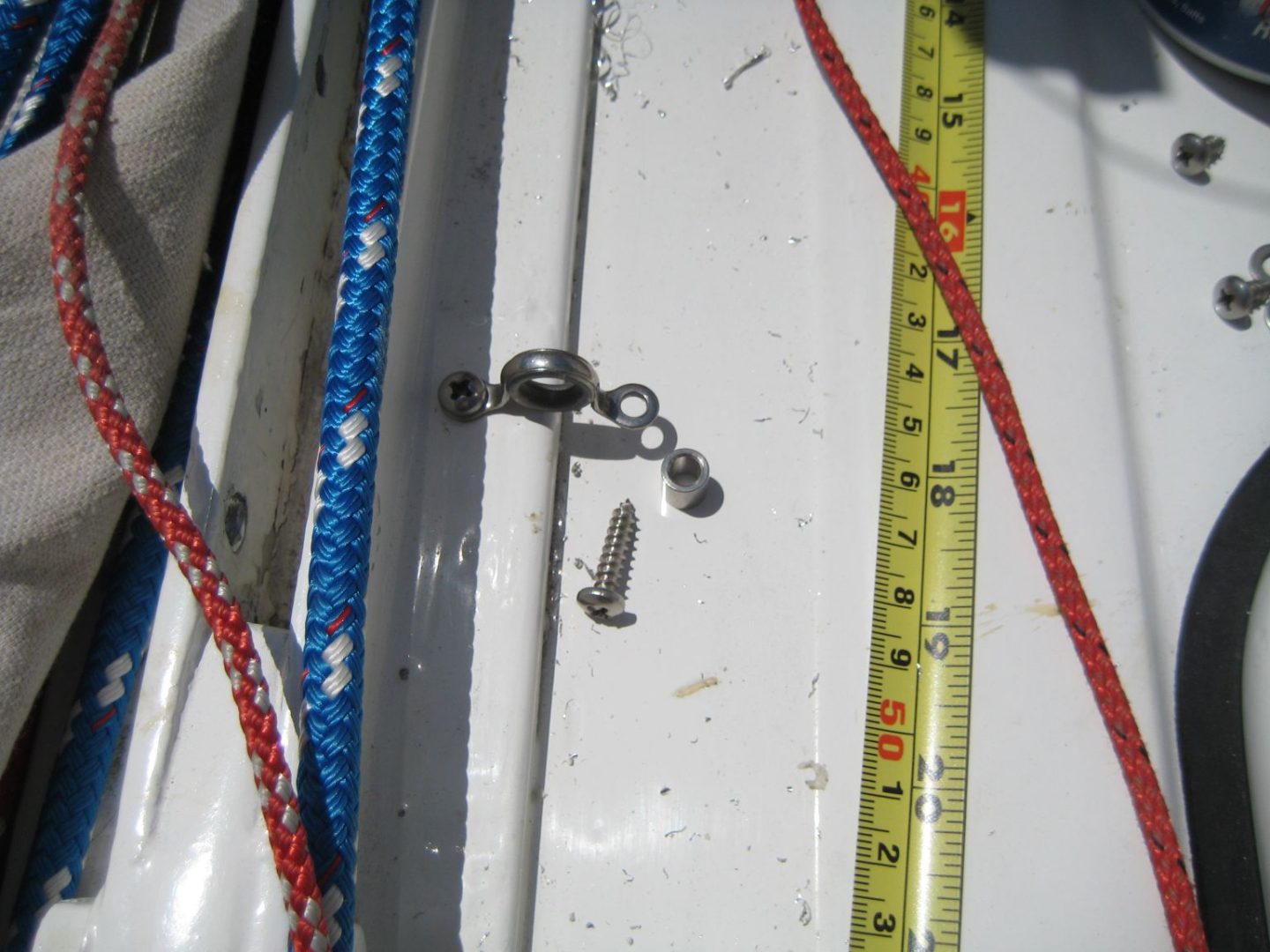 A white boat with a blue and red rope on it.