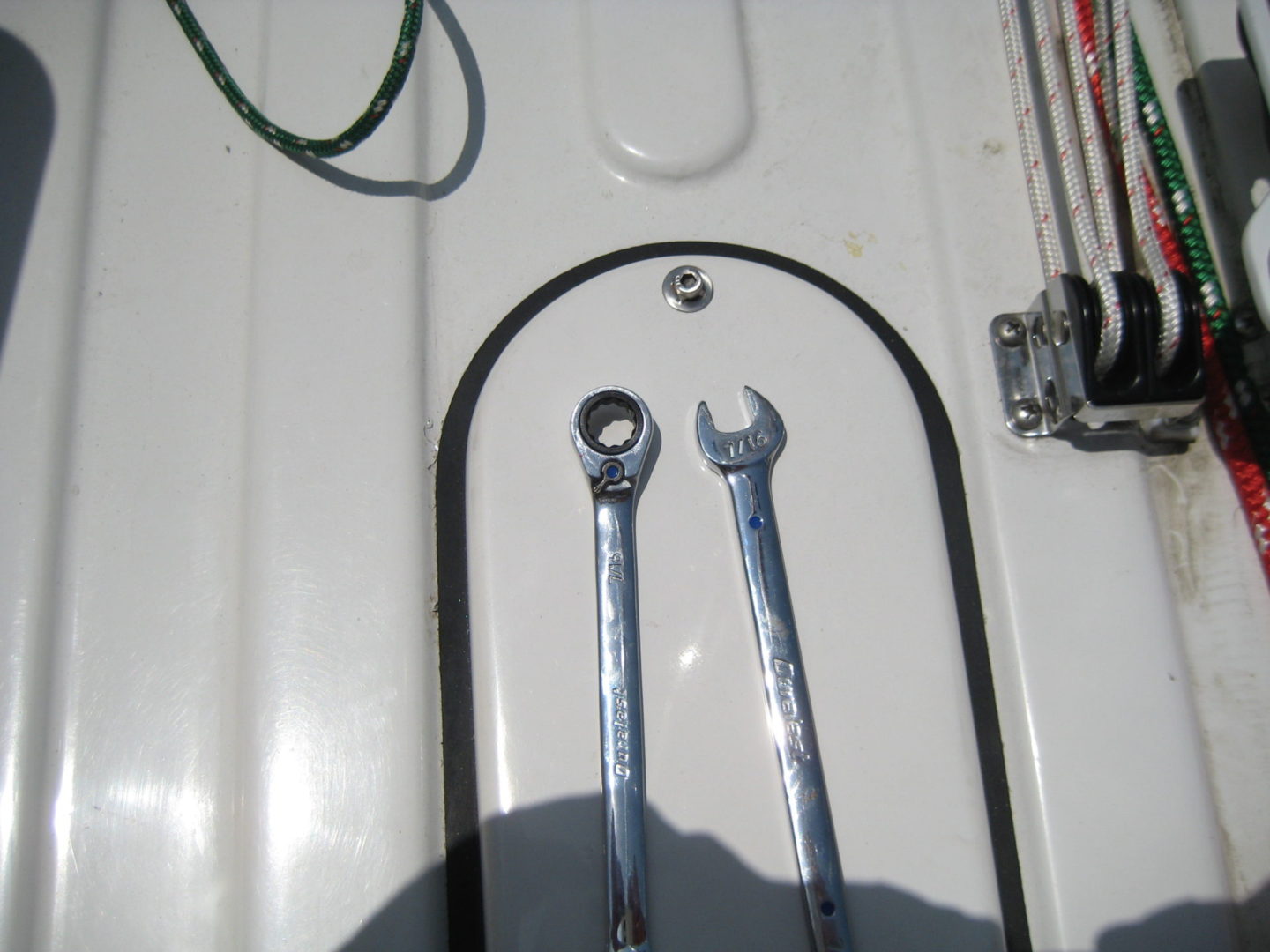 Two wrenches are sitting on the side of a boat.