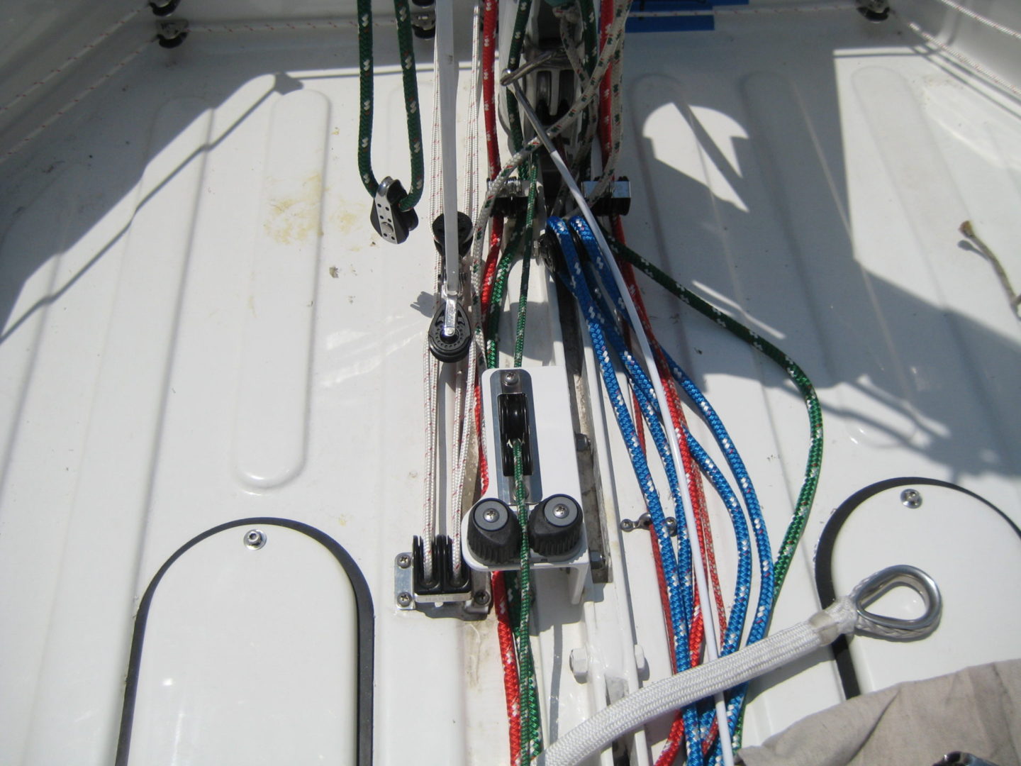 A bunch of wires are hanging on the side of a boat.