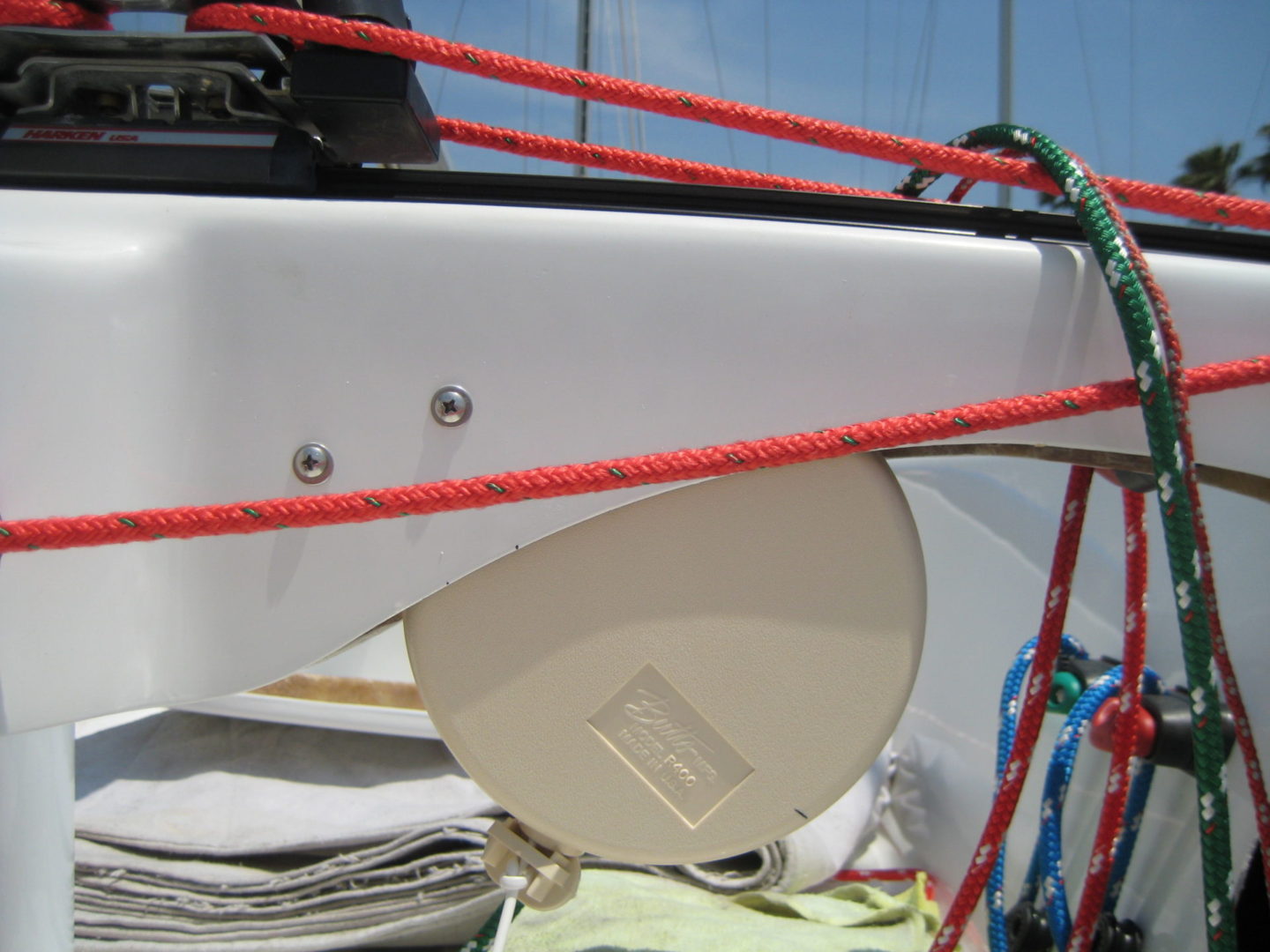 A white boat with red ropes on the side.