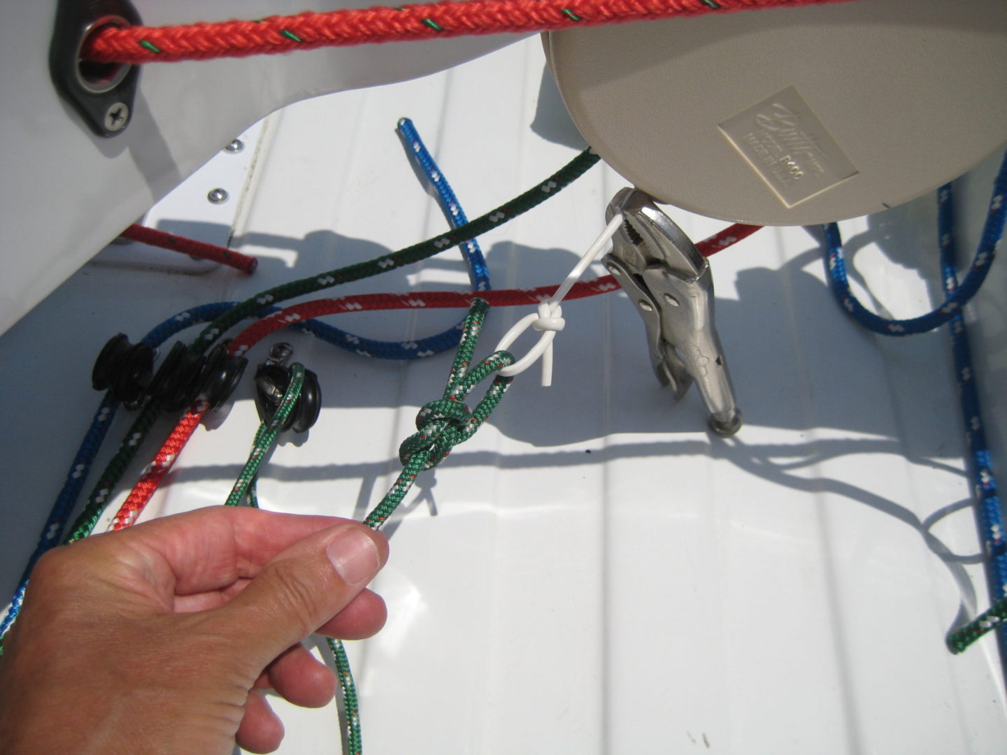 A person holding onto some ropes on the side of a boat.