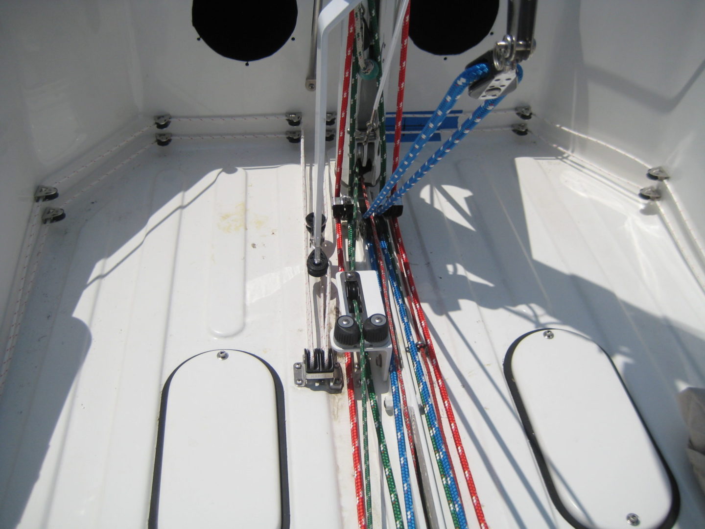 A boat with ropes and cables on the deck.