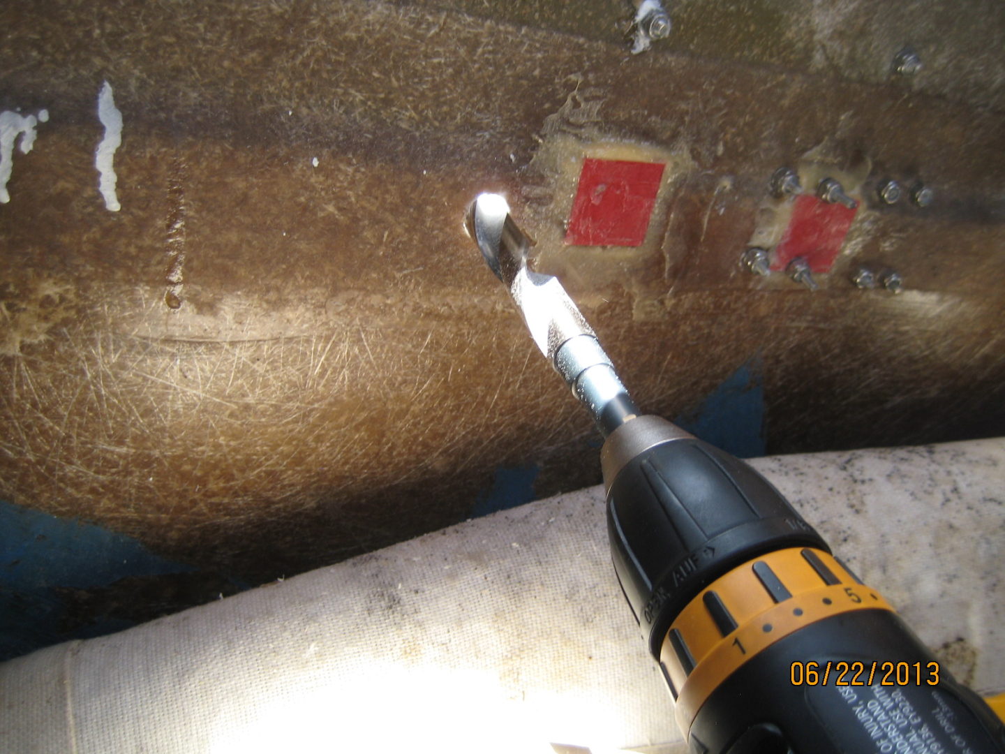 A drill is being used to remove the rust from a pipe.