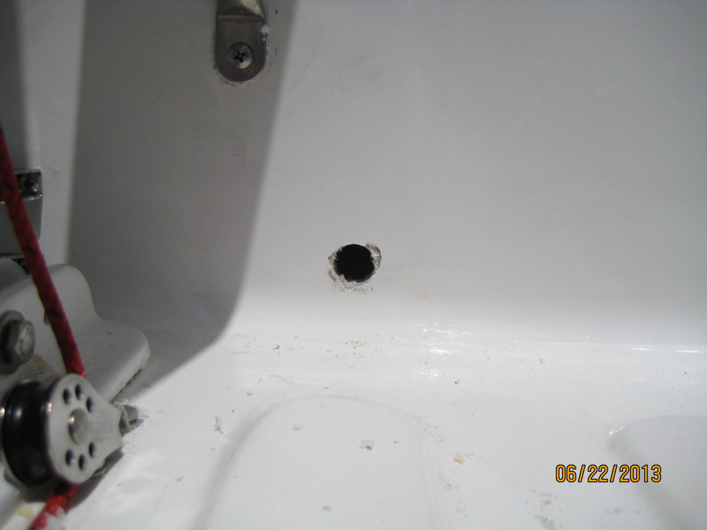 A hole in the wall of a bathroom sink.