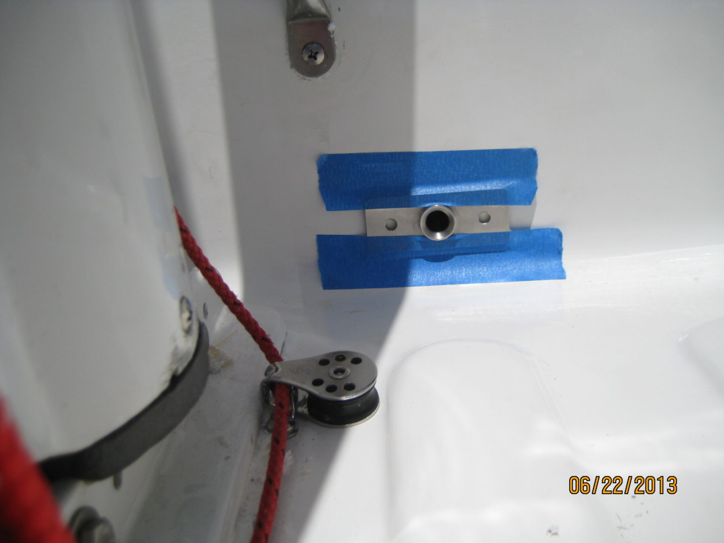 A close up of the bathroom shower with blue tape.