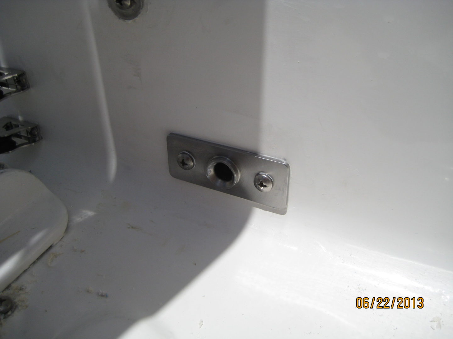 A metal plate with holes in it next to the sink.