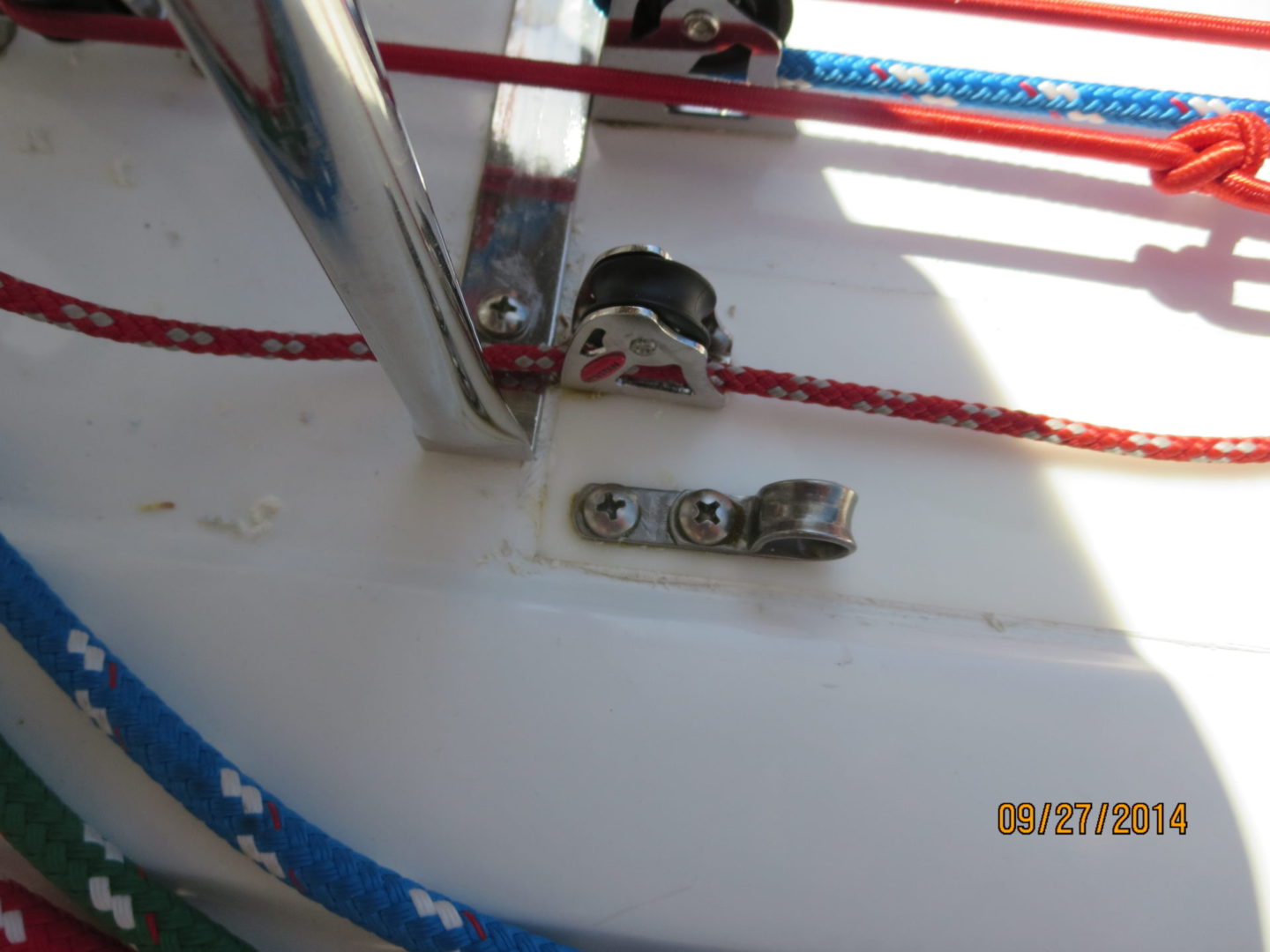 A close up of the side of a boat with ropes.