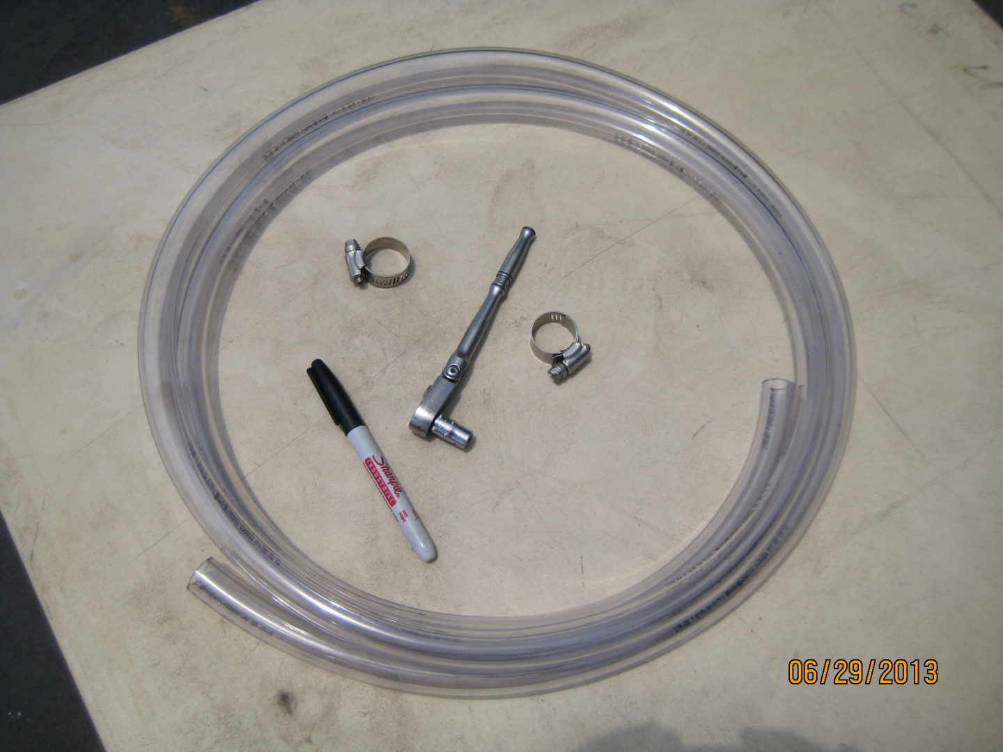 A clear hose with some parts and a marker