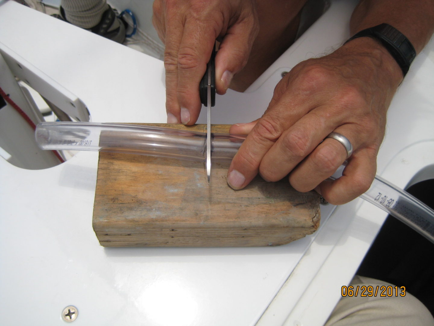 A person using a knife to cut through wood.