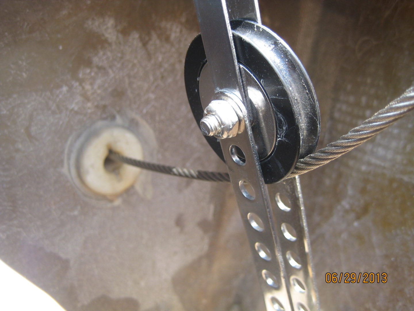 A close up of the pulley and rope on a metal device.