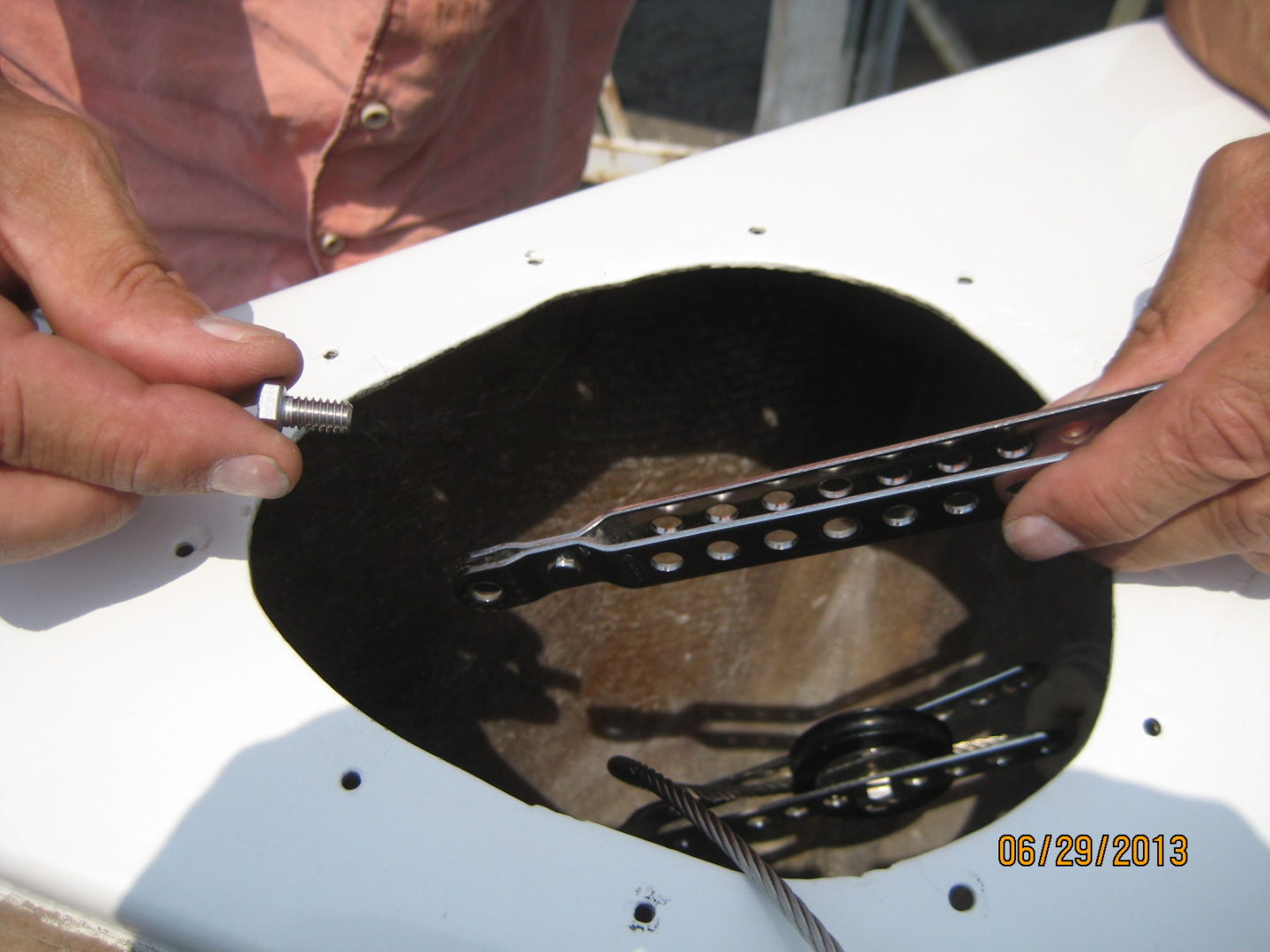 A person holding two forks in front of an open hole.