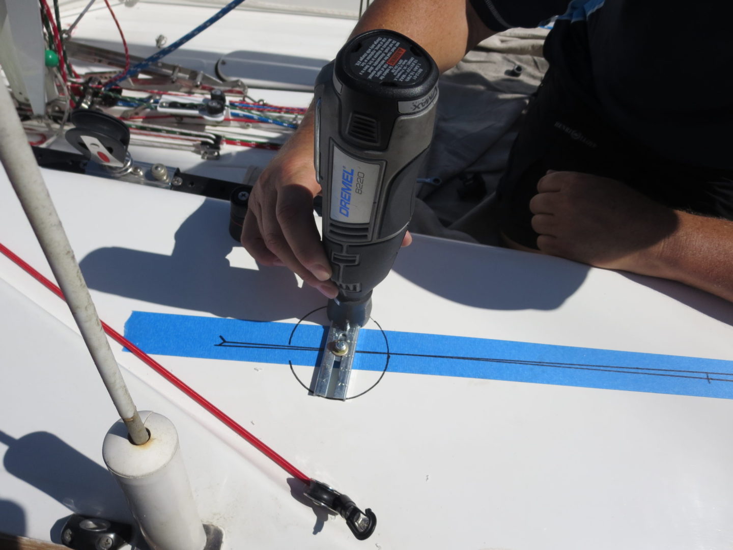 A person using a drill to make holes in the ground.