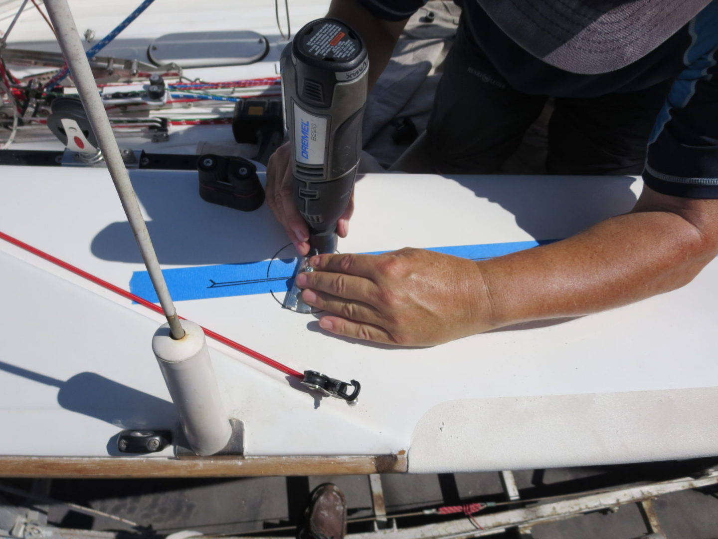 A person using a drill to make something on the boat.