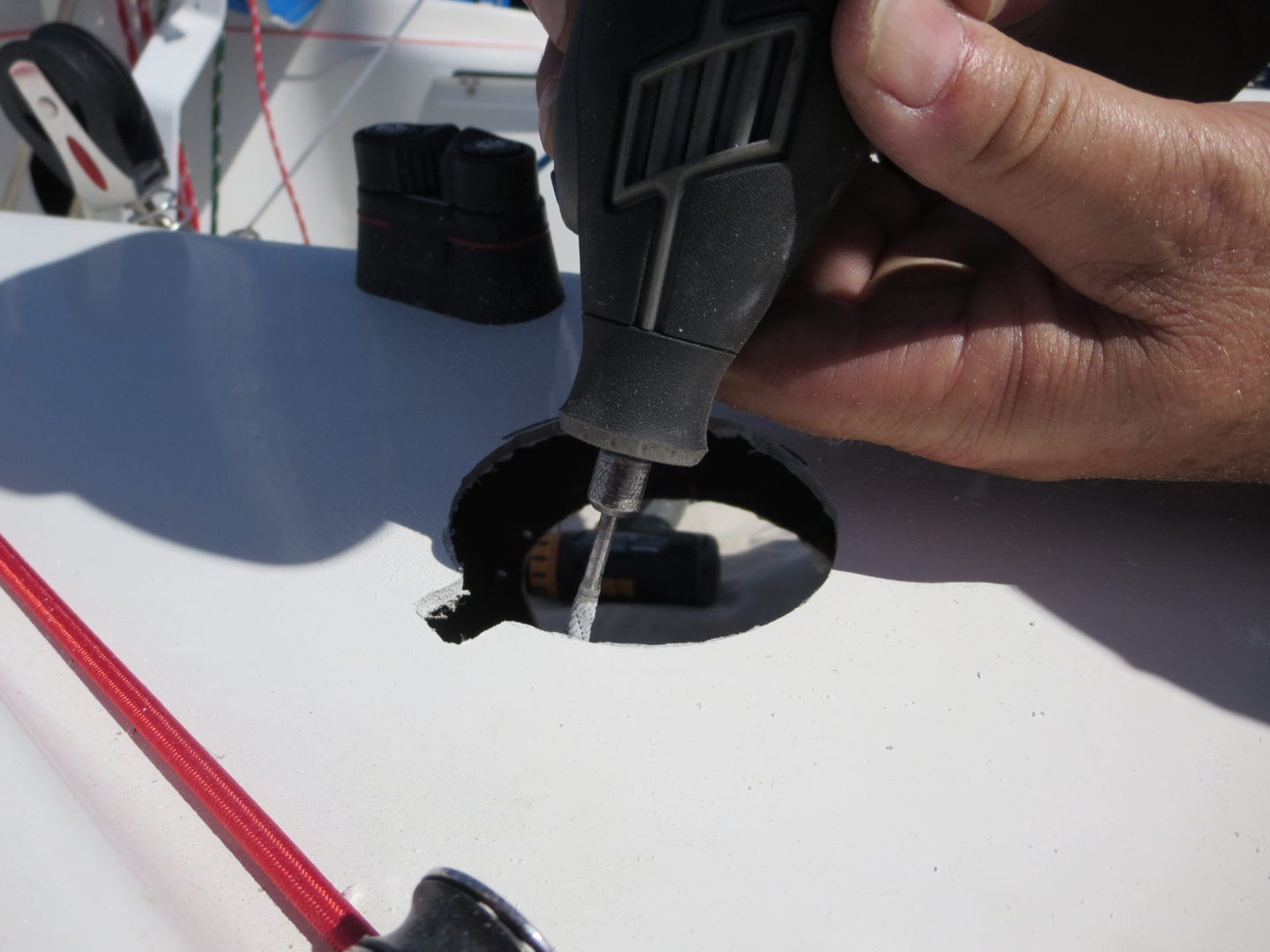 A person using a drill to hole the holes in the boat.