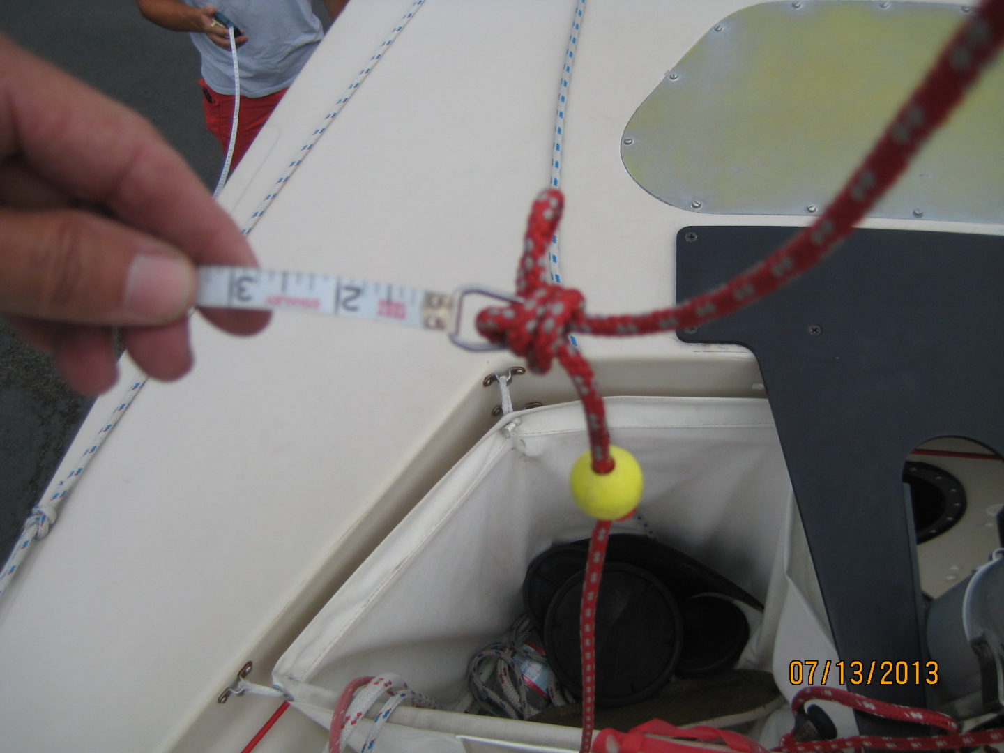 A person is tying the rope to the side of a boat.