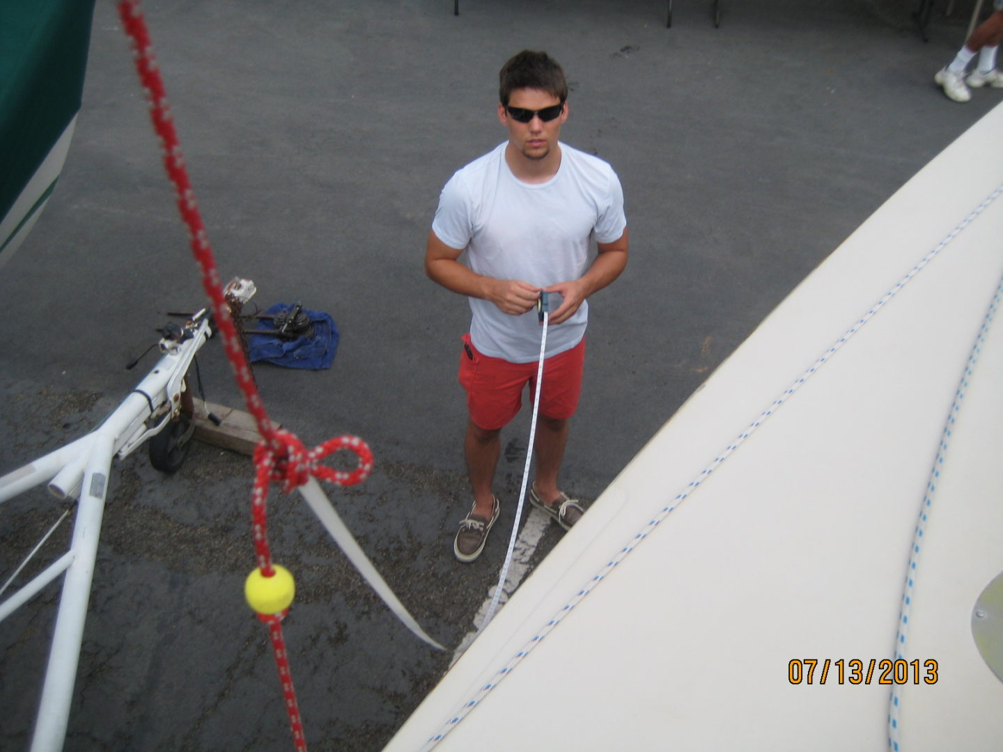 A man standing next to a boat on the water.