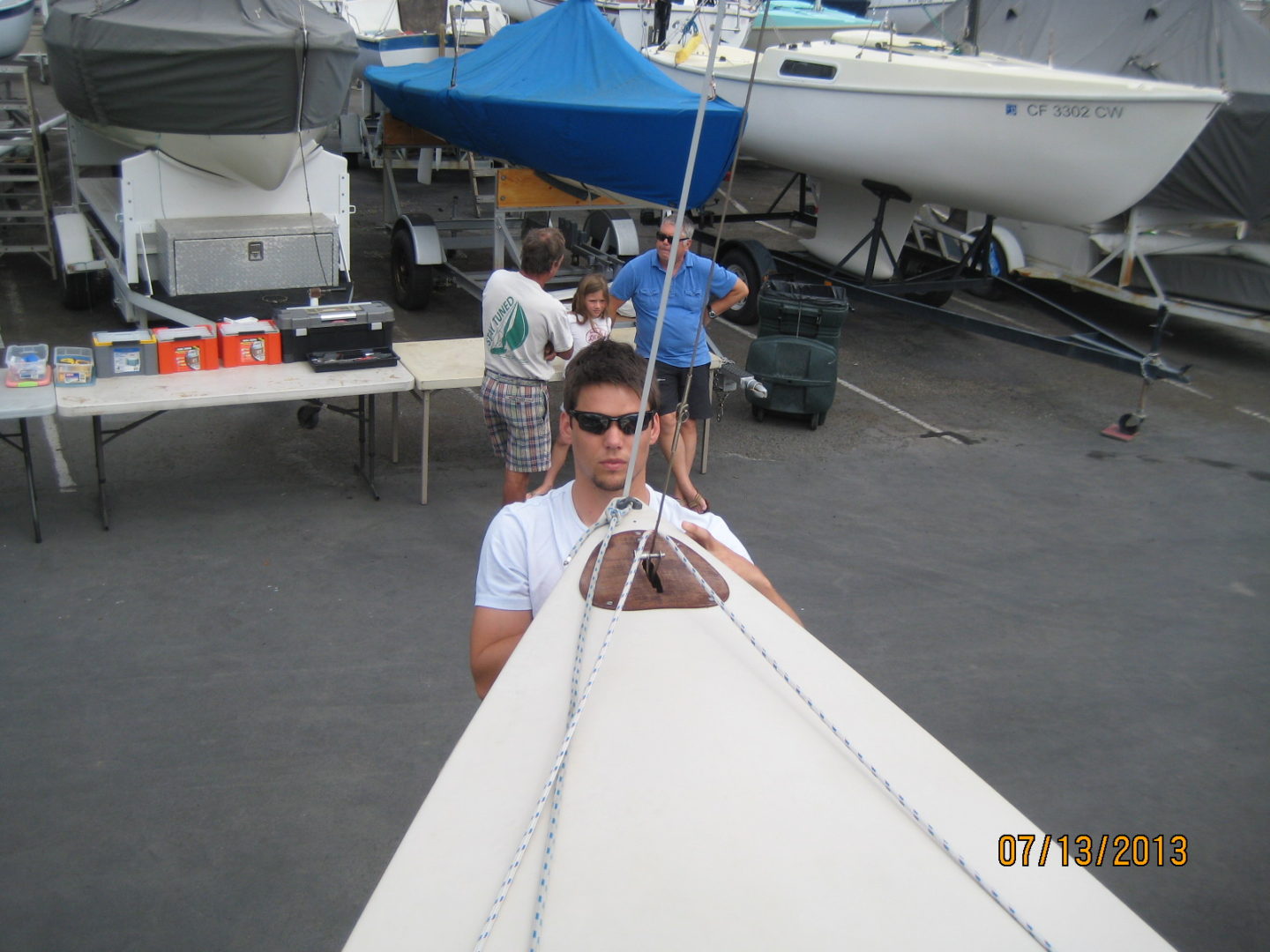 A man standing next to a boat on the water.