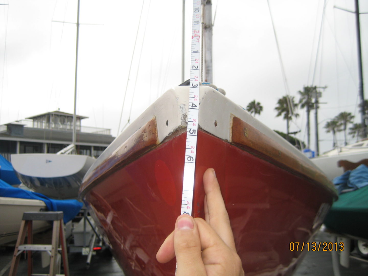 A person measuring the sail of a boat.