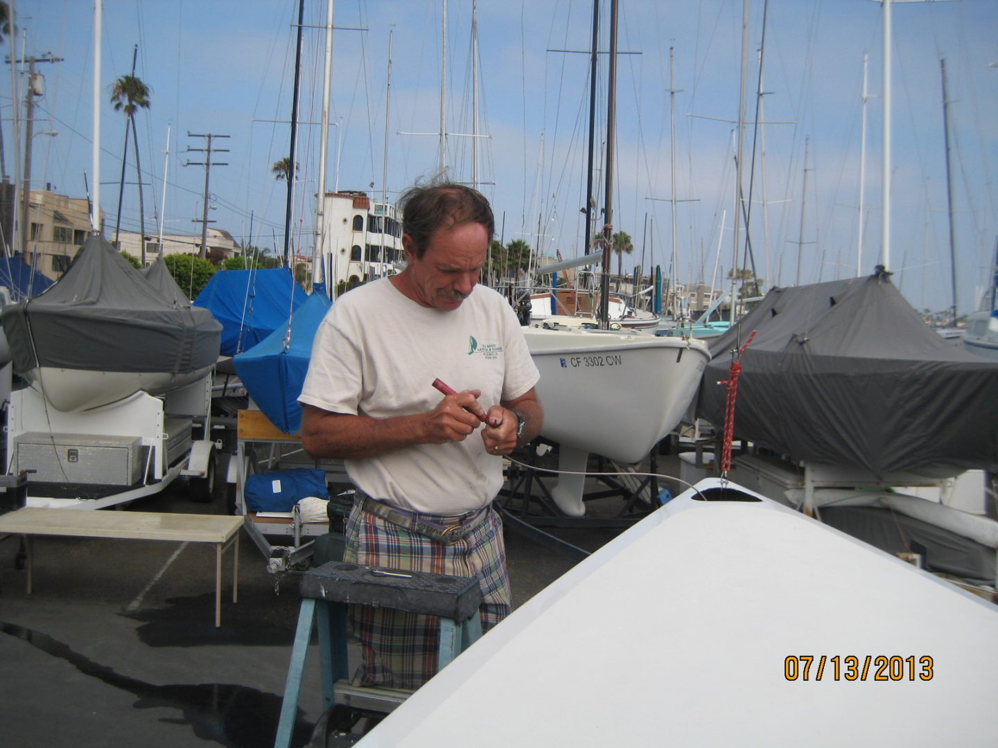 A man standing in front of boats on the water.