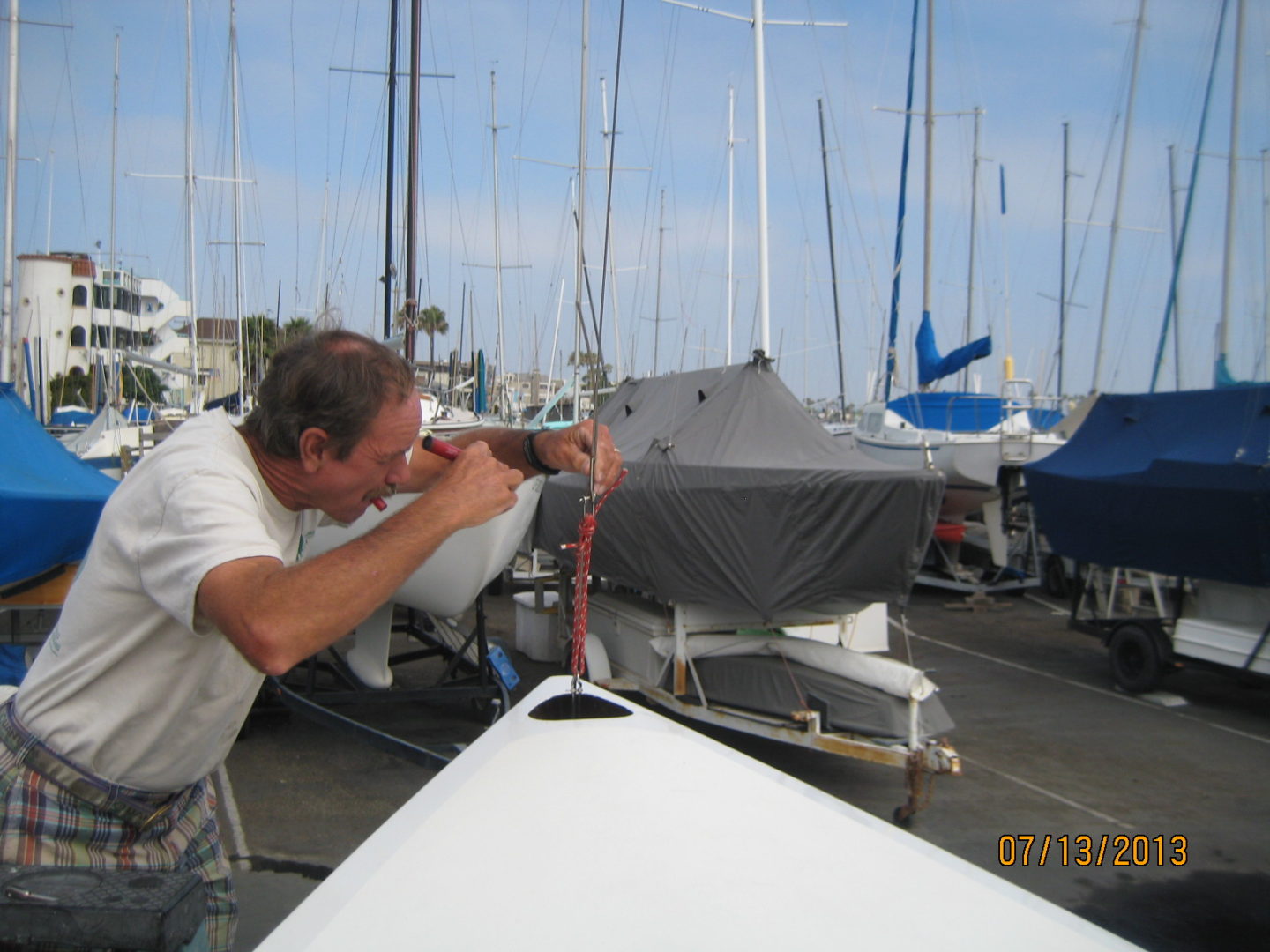 A man is working on the side of a boat.