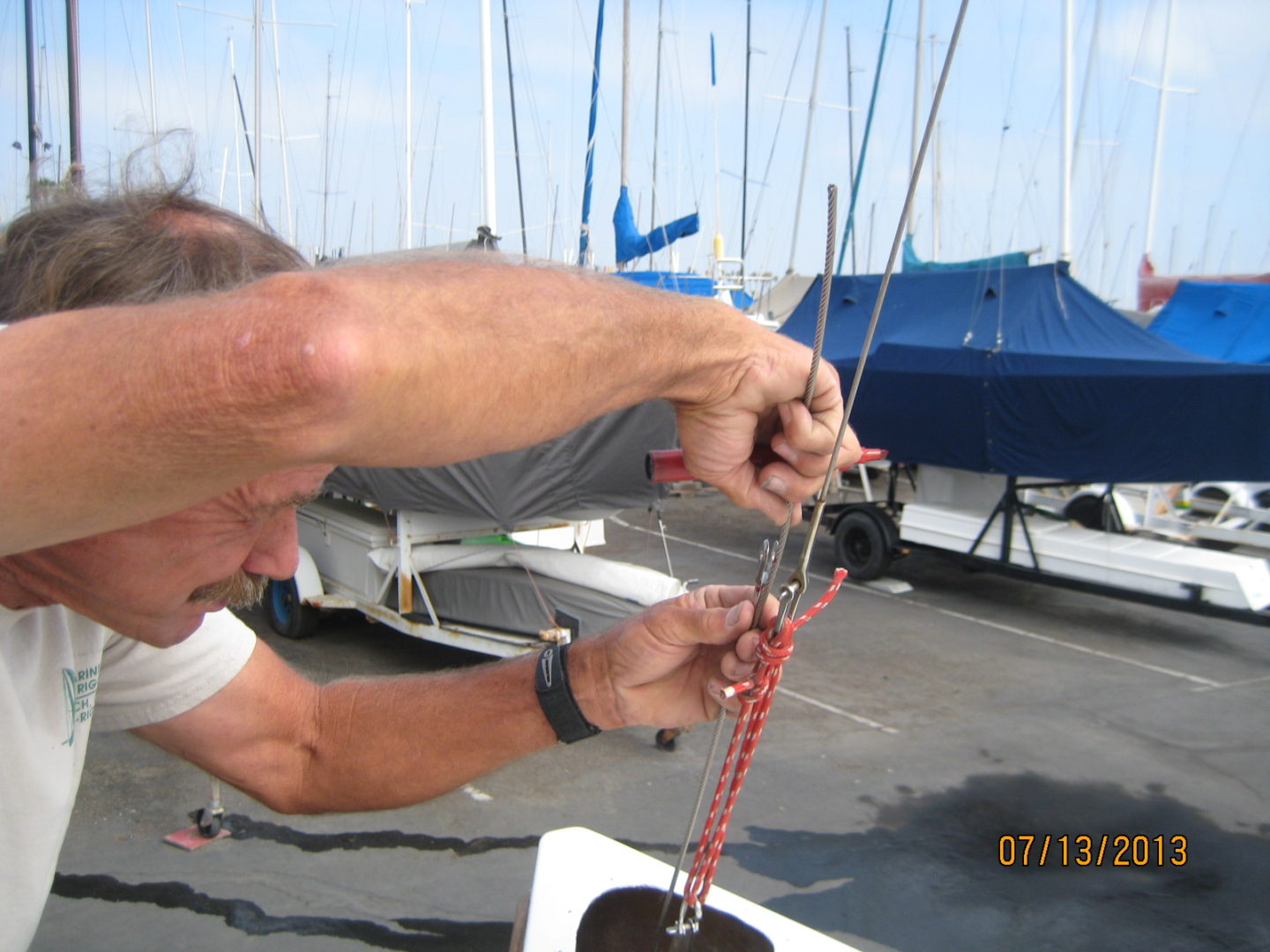 A man is tying the rope to the sail.