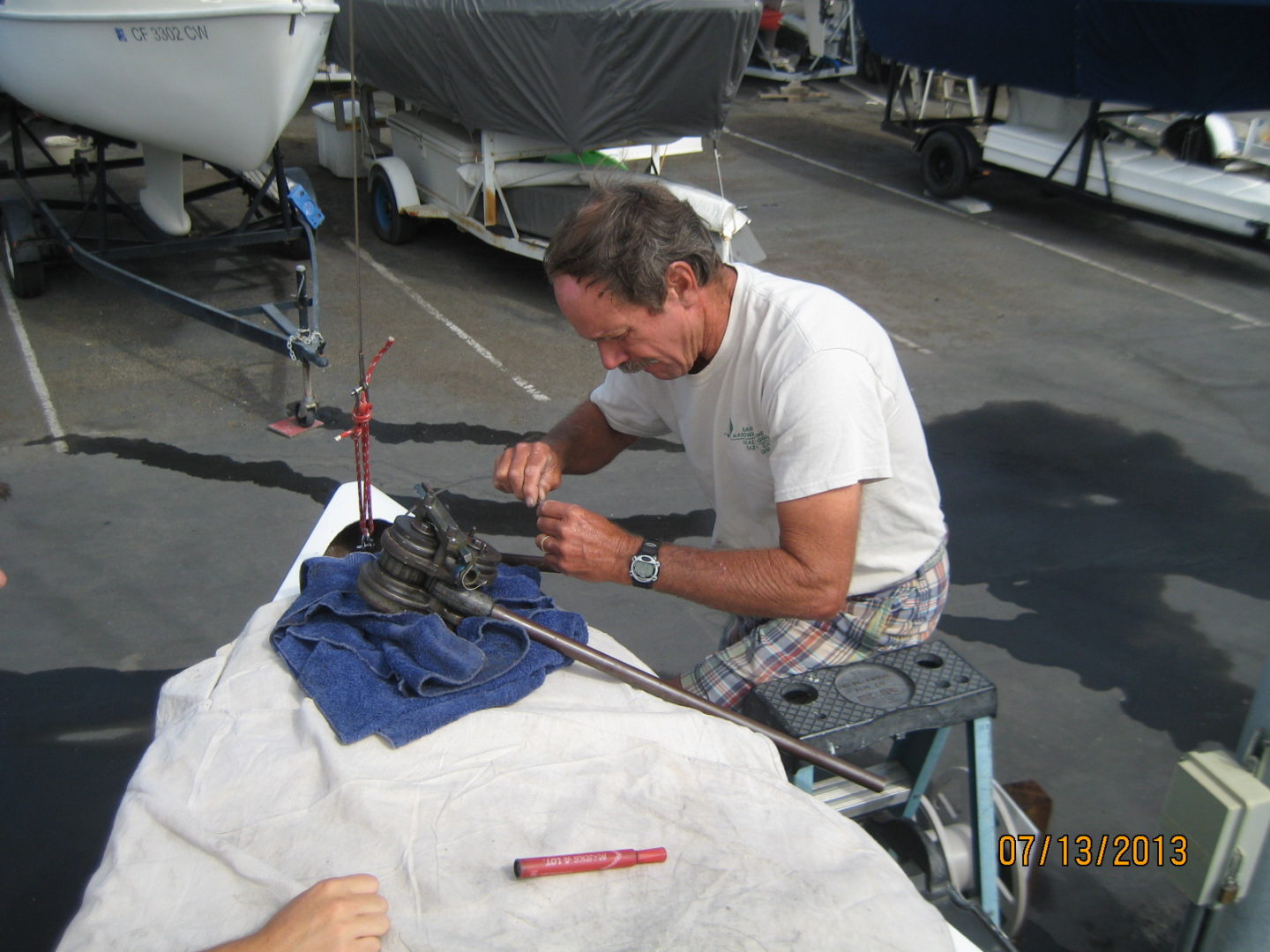 A man is painting the boat 's hull.