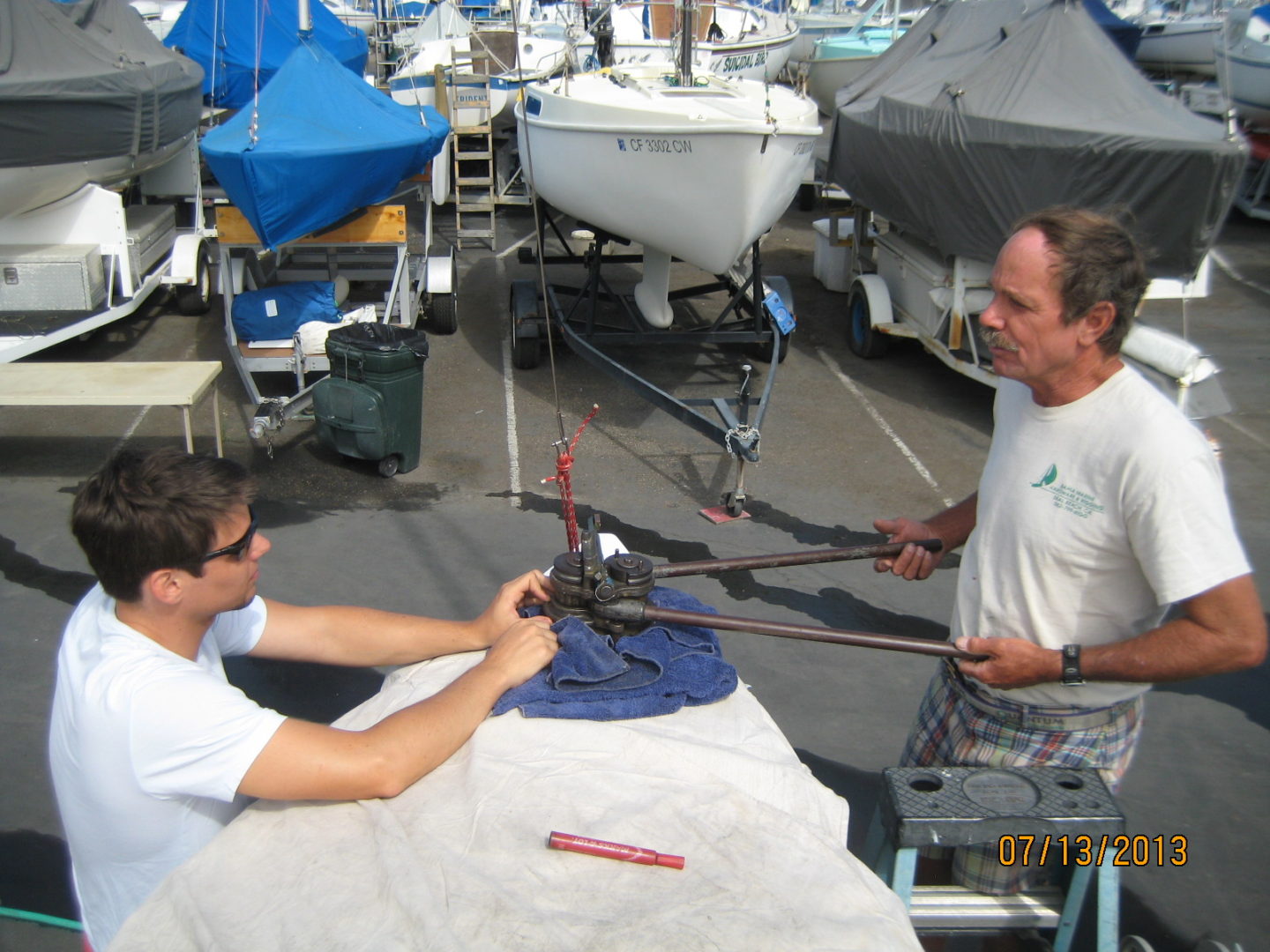 Two men are sitting at a table with ropes.