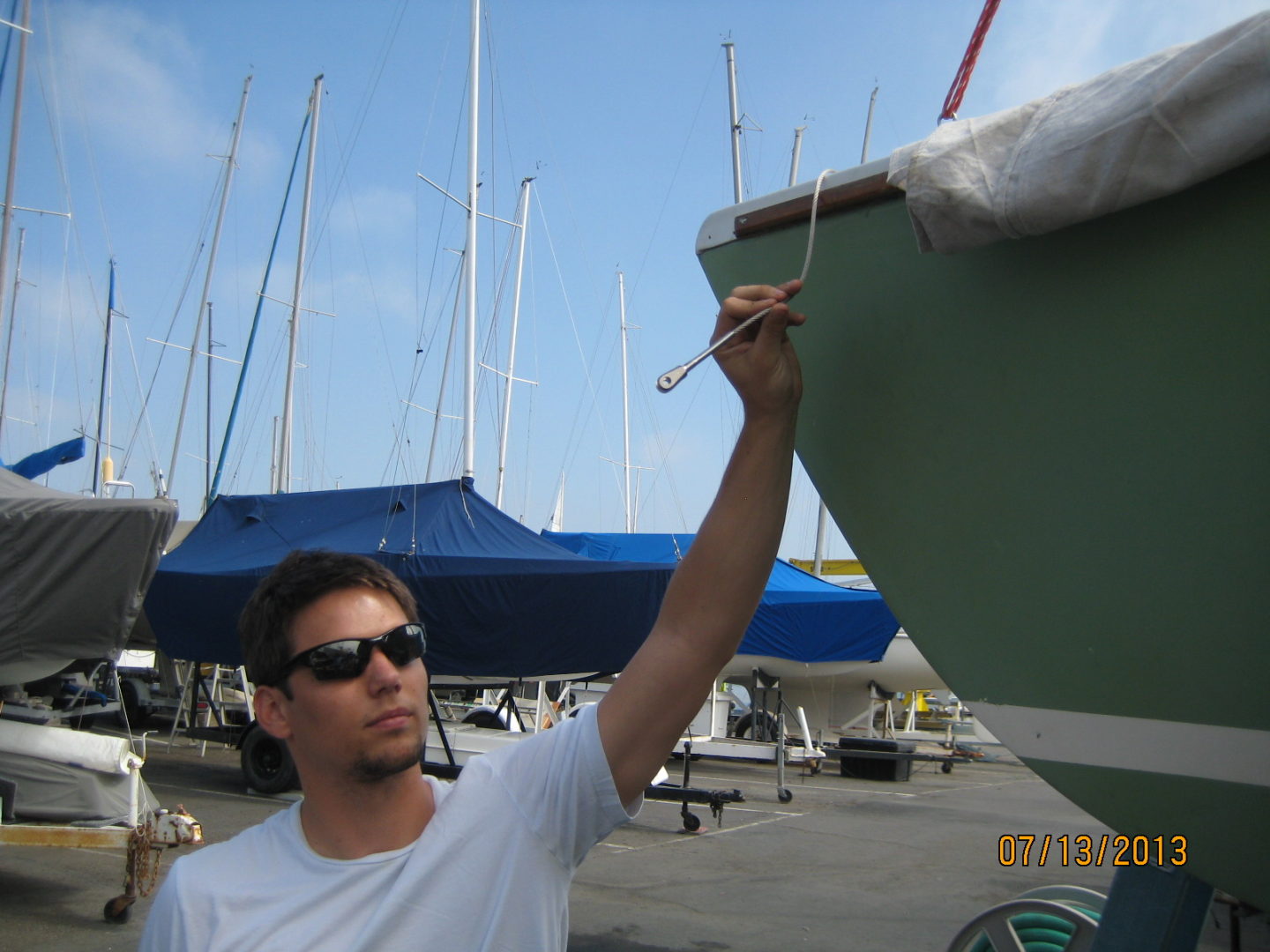 A man painting on the side of a boat.