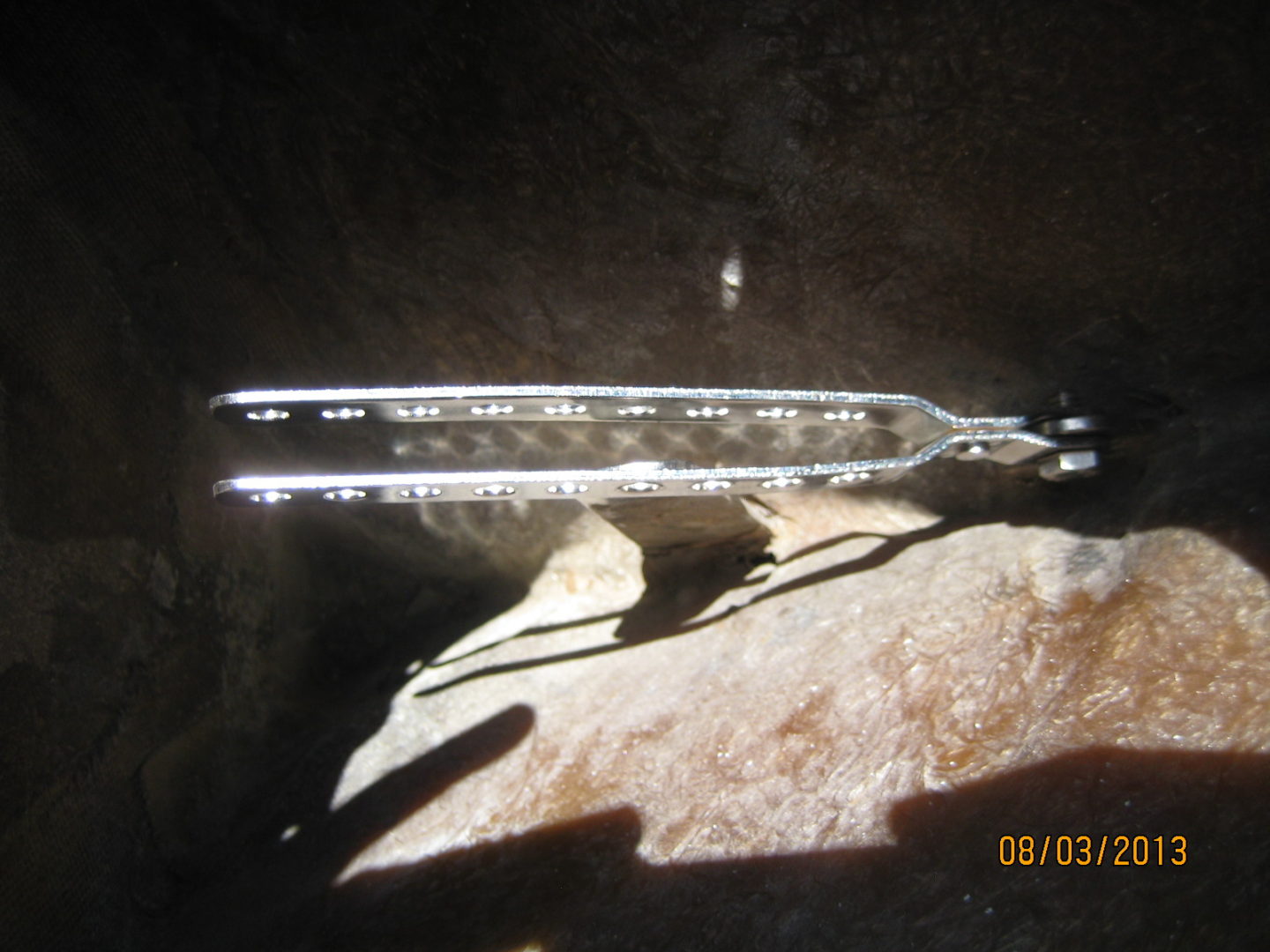 A thermometer is shown on the ground near some rocks.