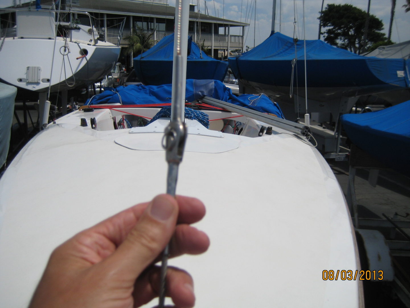 A person holding scissors in front of boats.