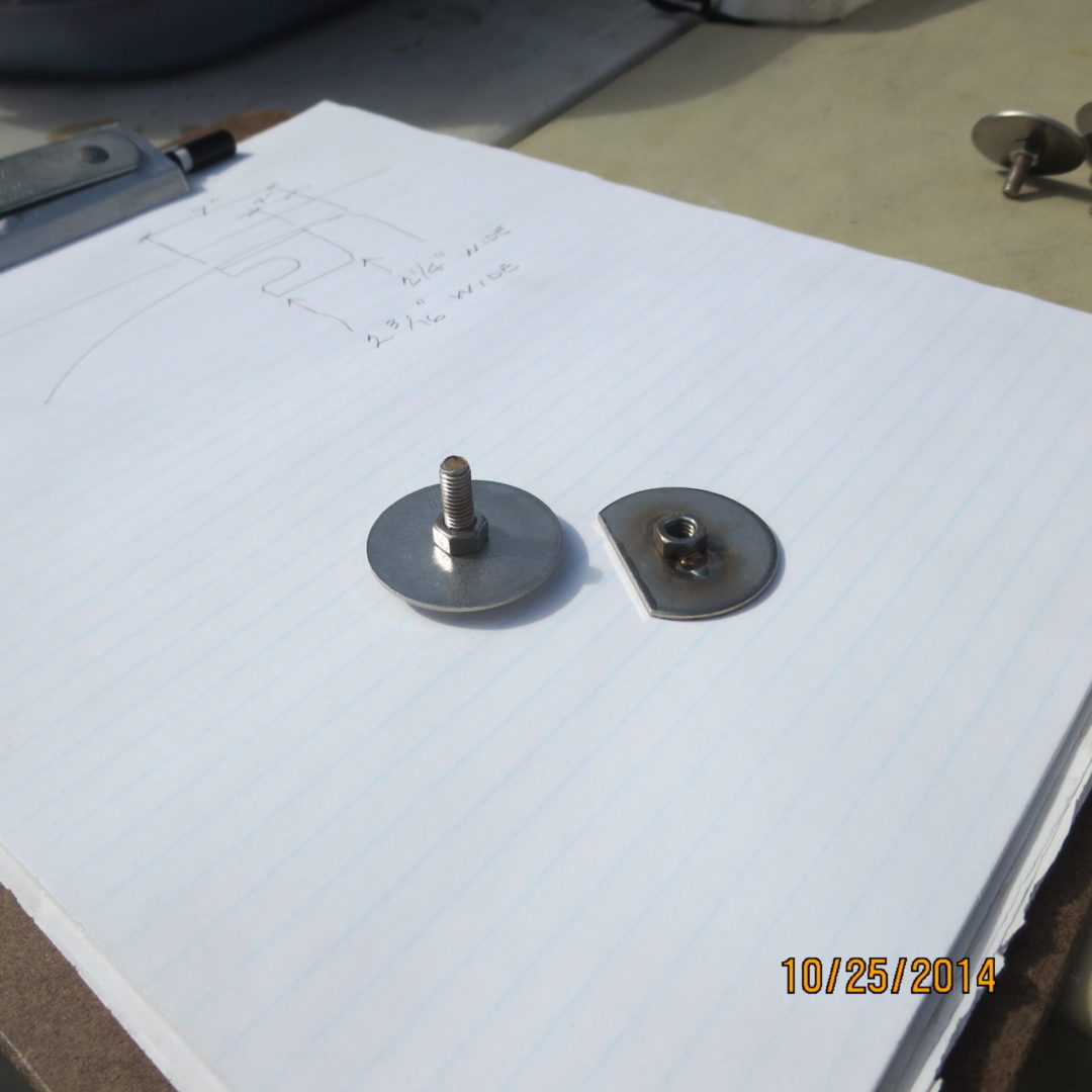 A pair of metal discs and a nut on top of paper.