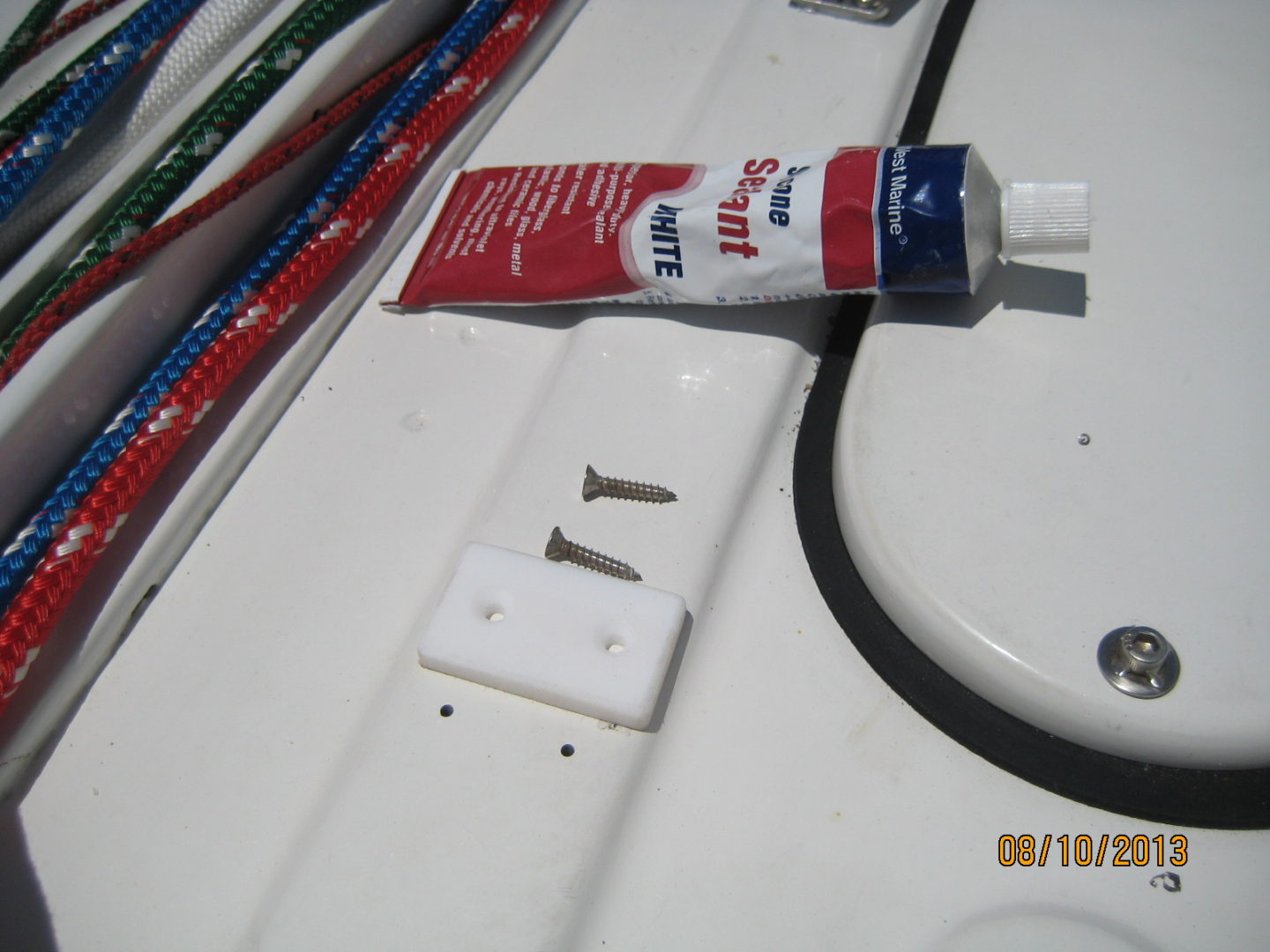 A tube of toothpaste is sitting on the side of a boat.